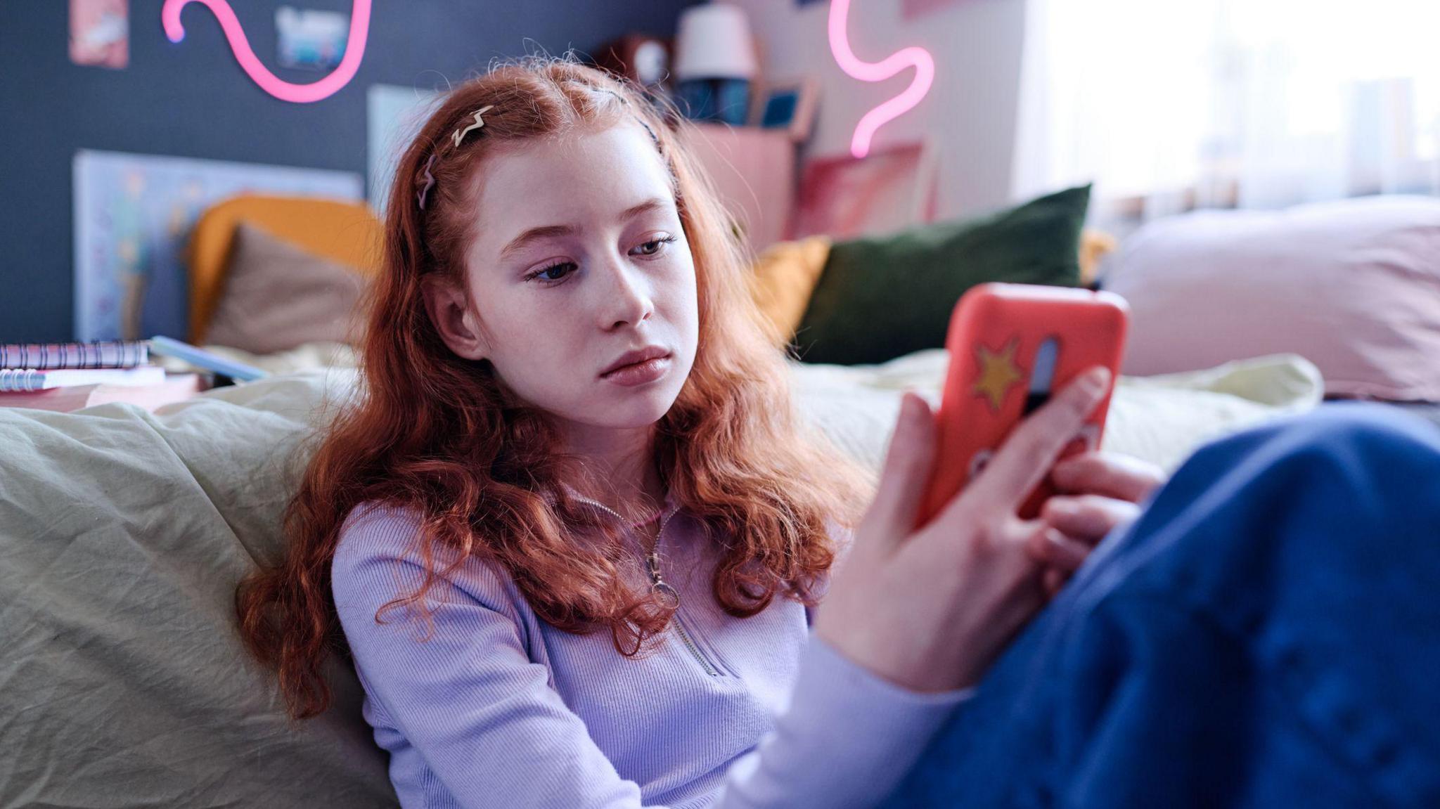 Girl looking sad while looking at smartphone. 