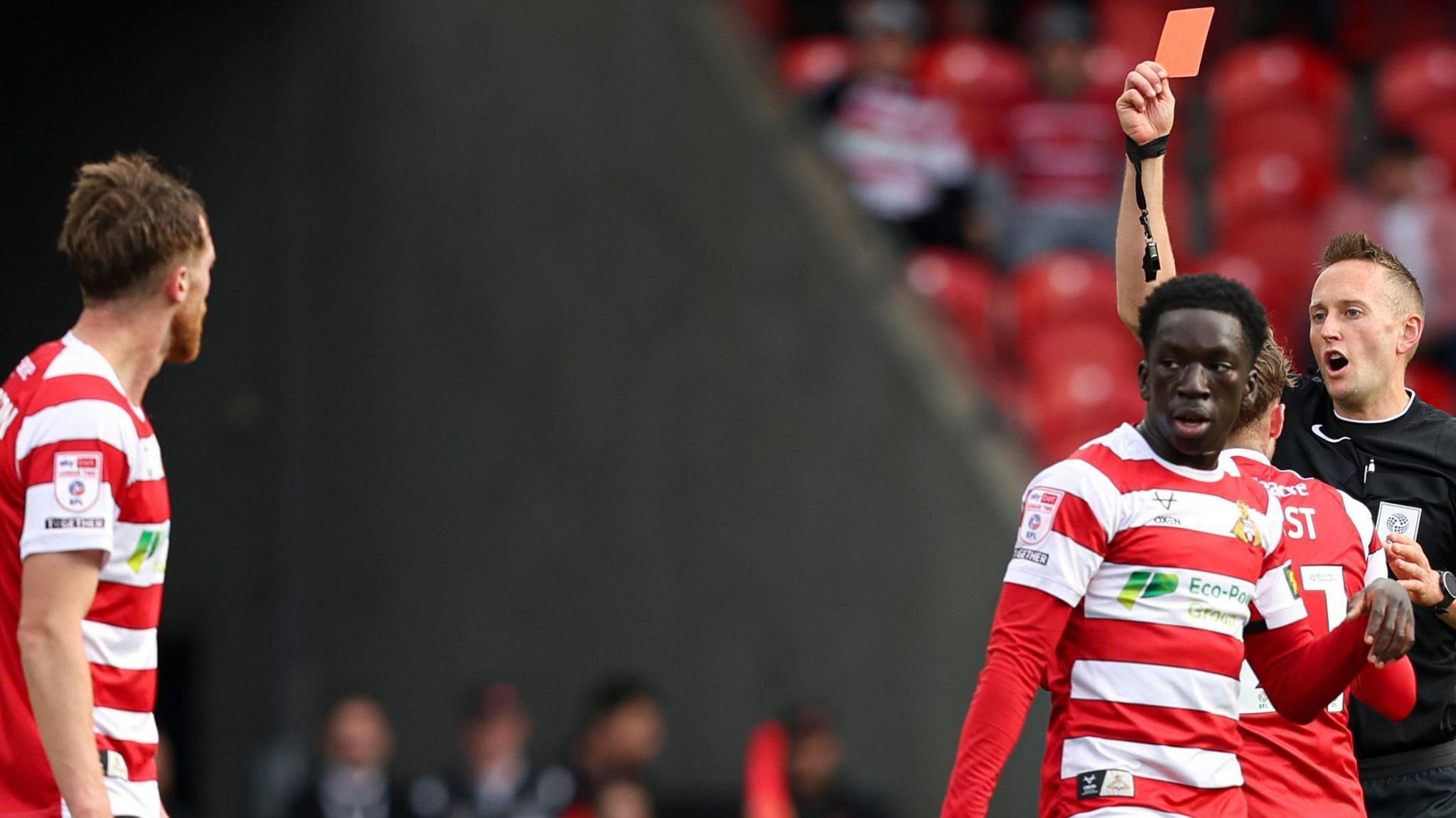 Doncaster defender Tom Anderson (left) is sent off by referee James Bell