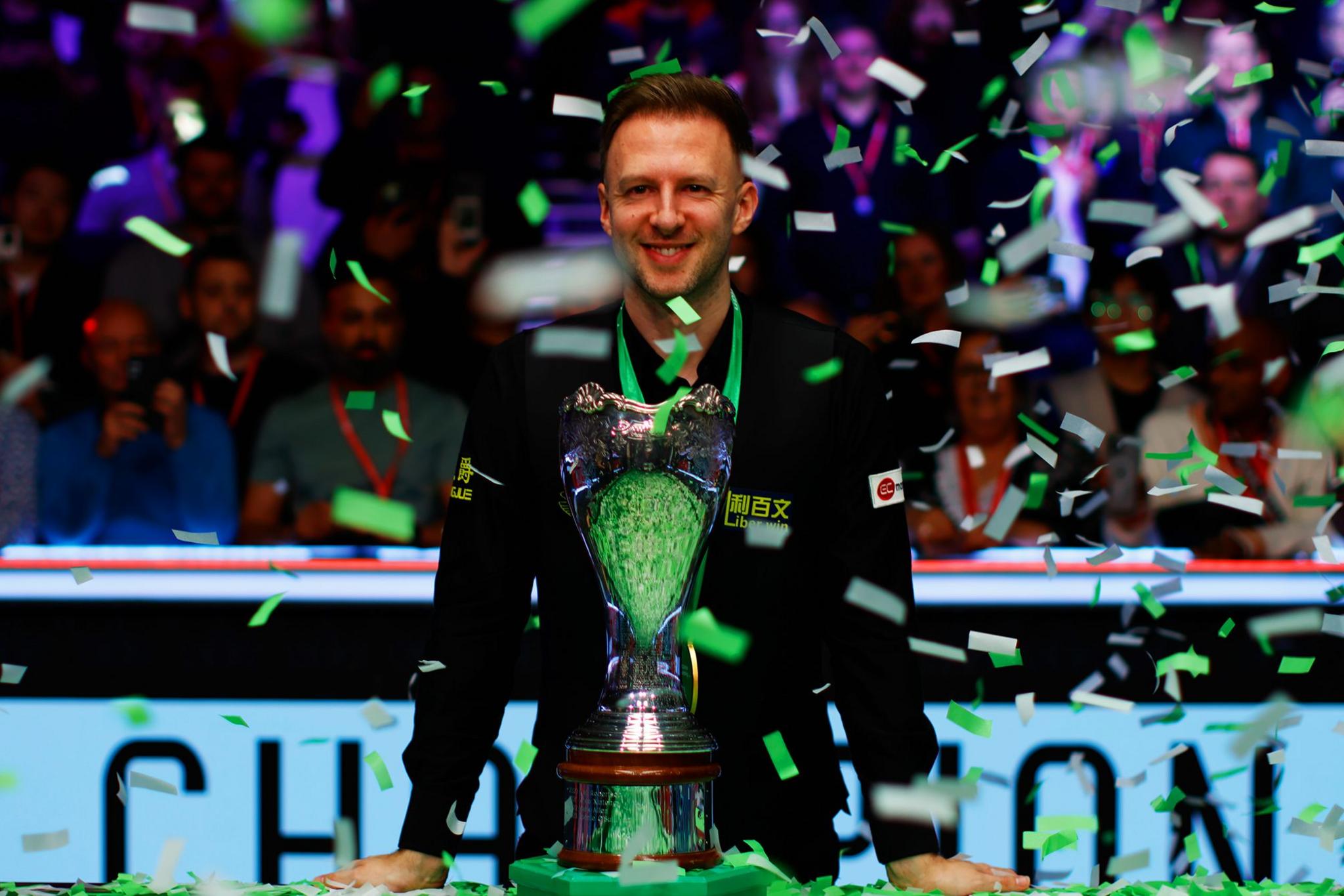 Judd Trump poses with the trophy with ticker-tape falling after winning the Final against Barry Hawkins of the UK Championship at Barbican Centre.