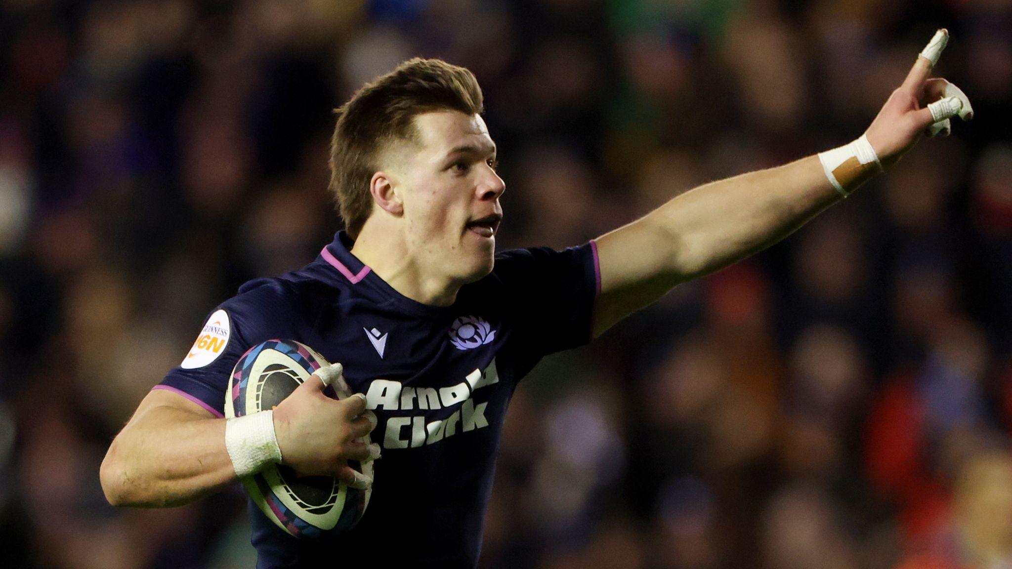 Scottish rugby player with ball in hand celebrates before scoring