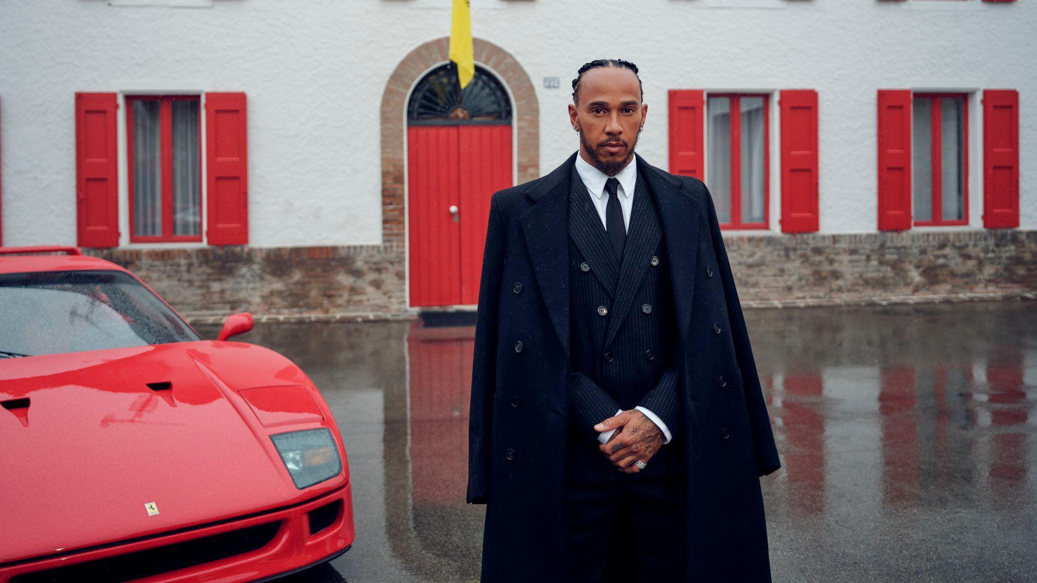 Lewis Hamilton stands in front of a Ferrari car at Maranello on his first official day at Ferrari 