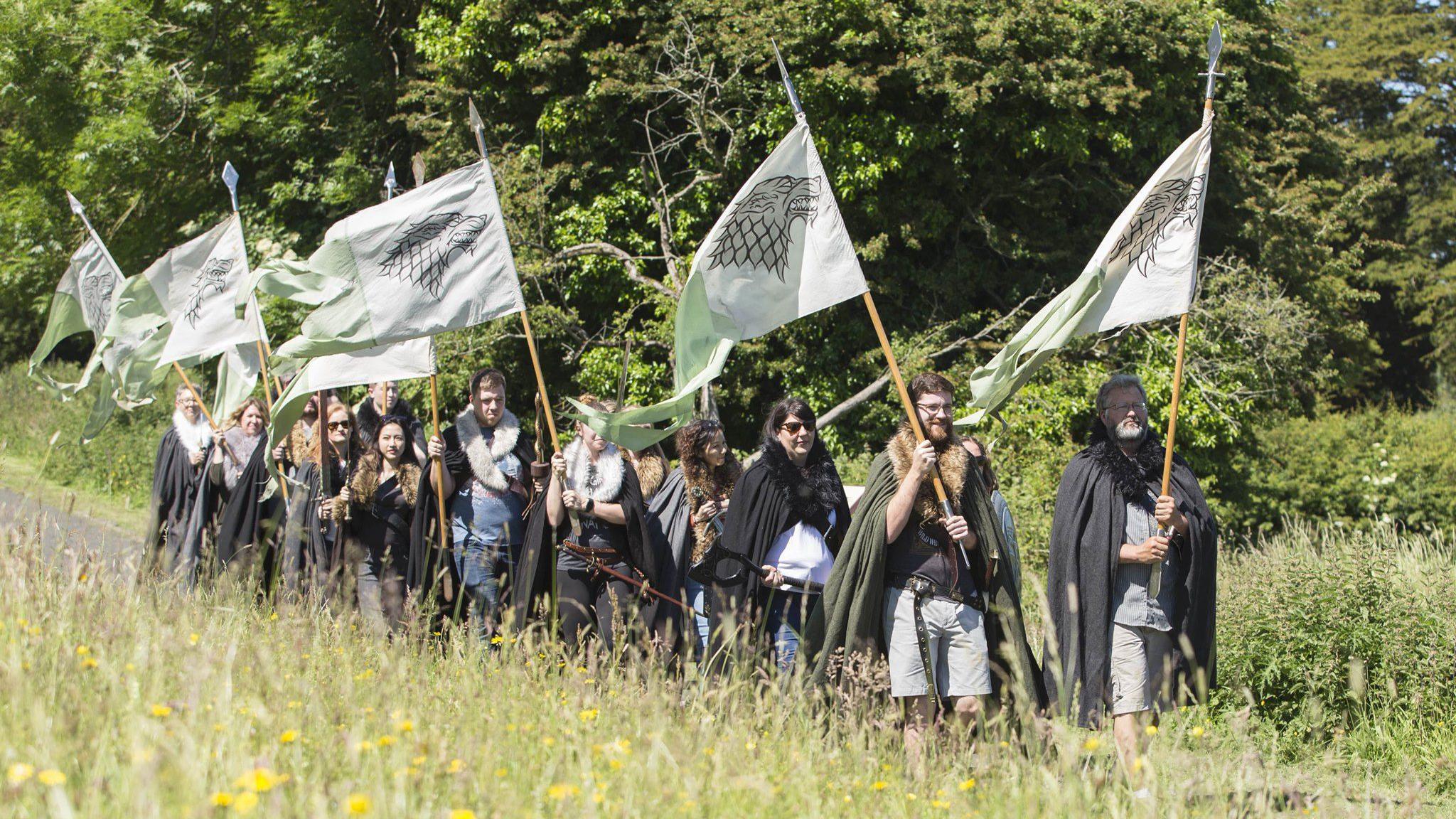 Game of thrones fans in costume holding flags on a tour 