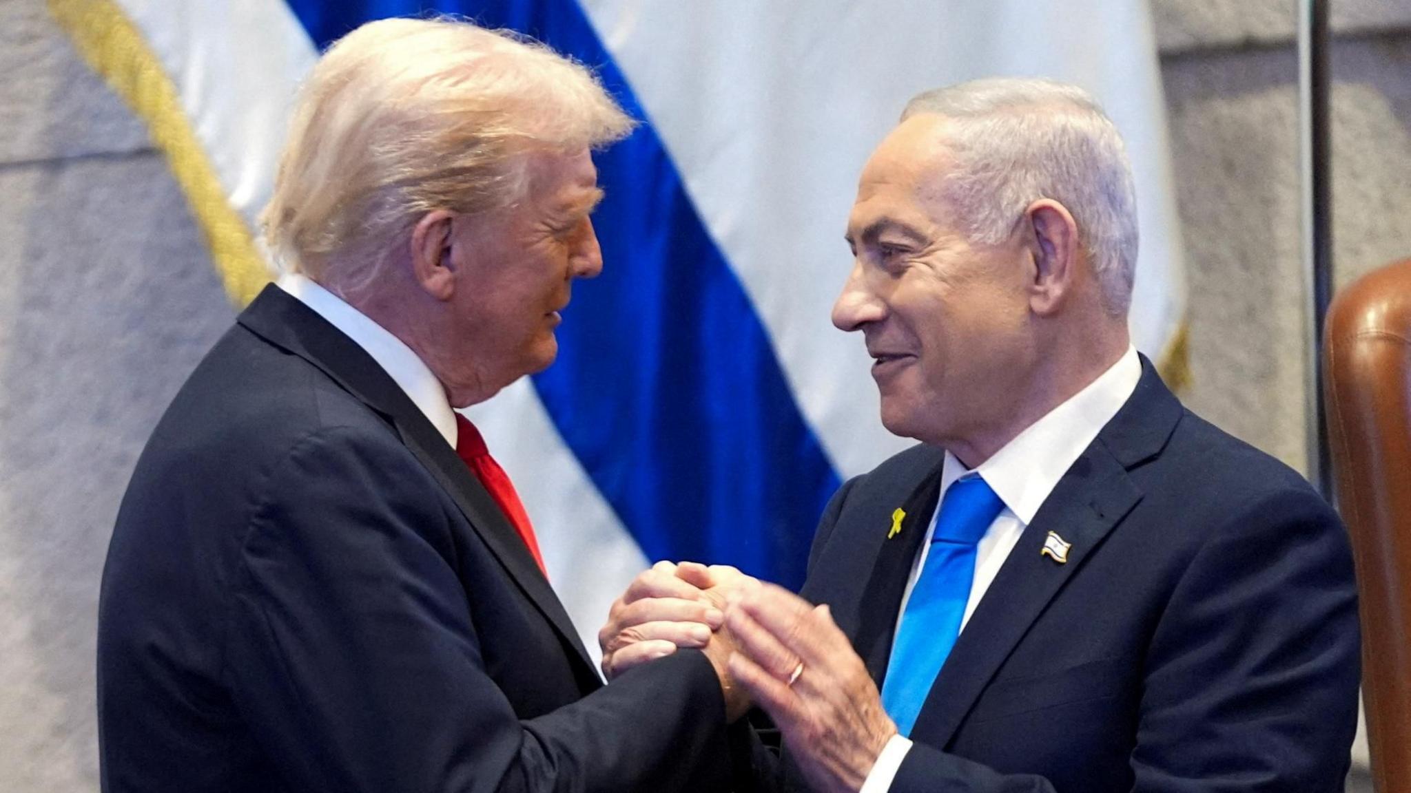 US President Donald Trump (L) shakes hands with Israeli Prime Minister Benjamin Netanyahu (R) during an address to the Israeli parliament in Jerusalem (13 October 2025)