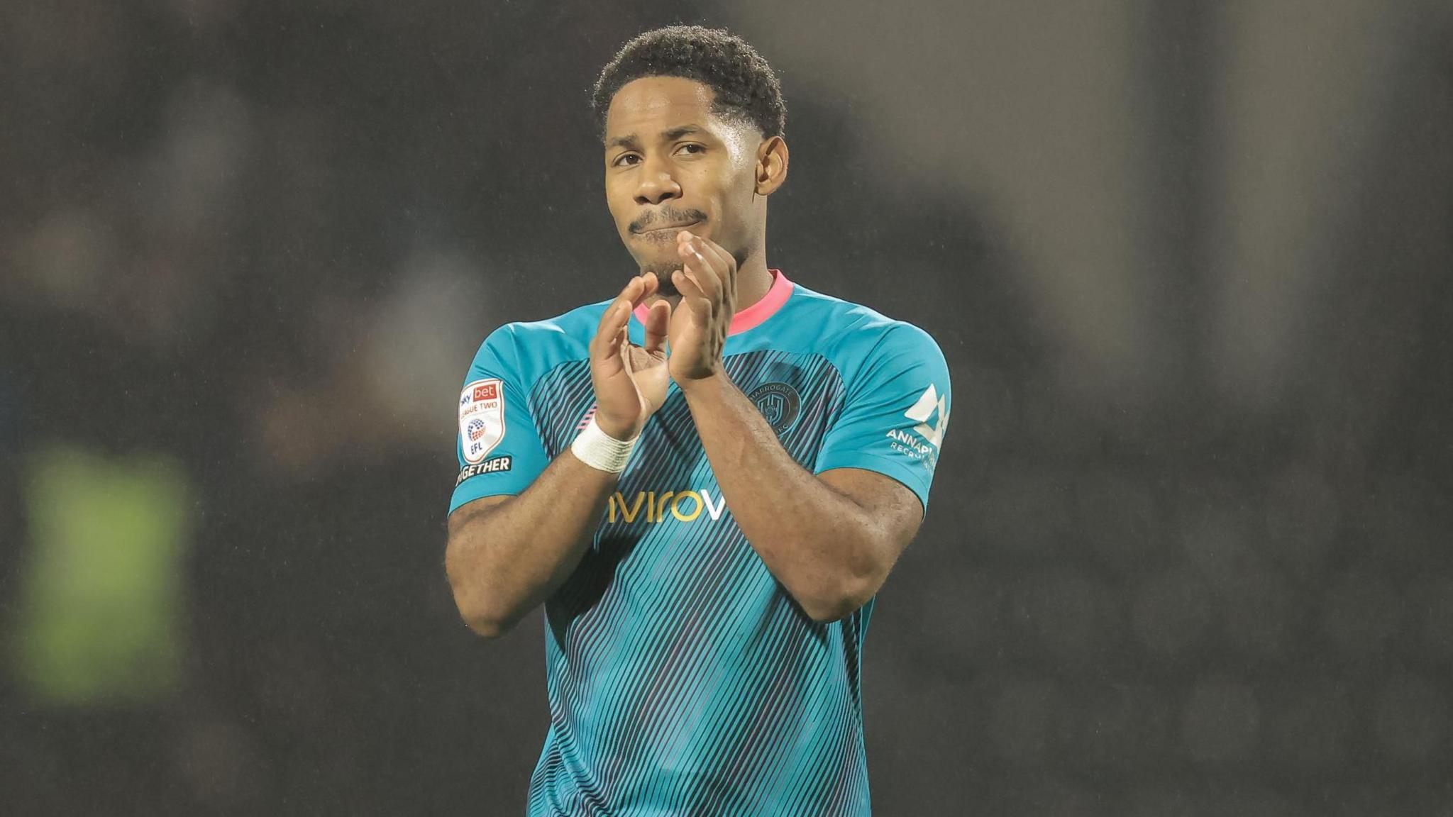 Zico Asare applauds the Harrogate Town fans after their League Two game at Notts County in November.