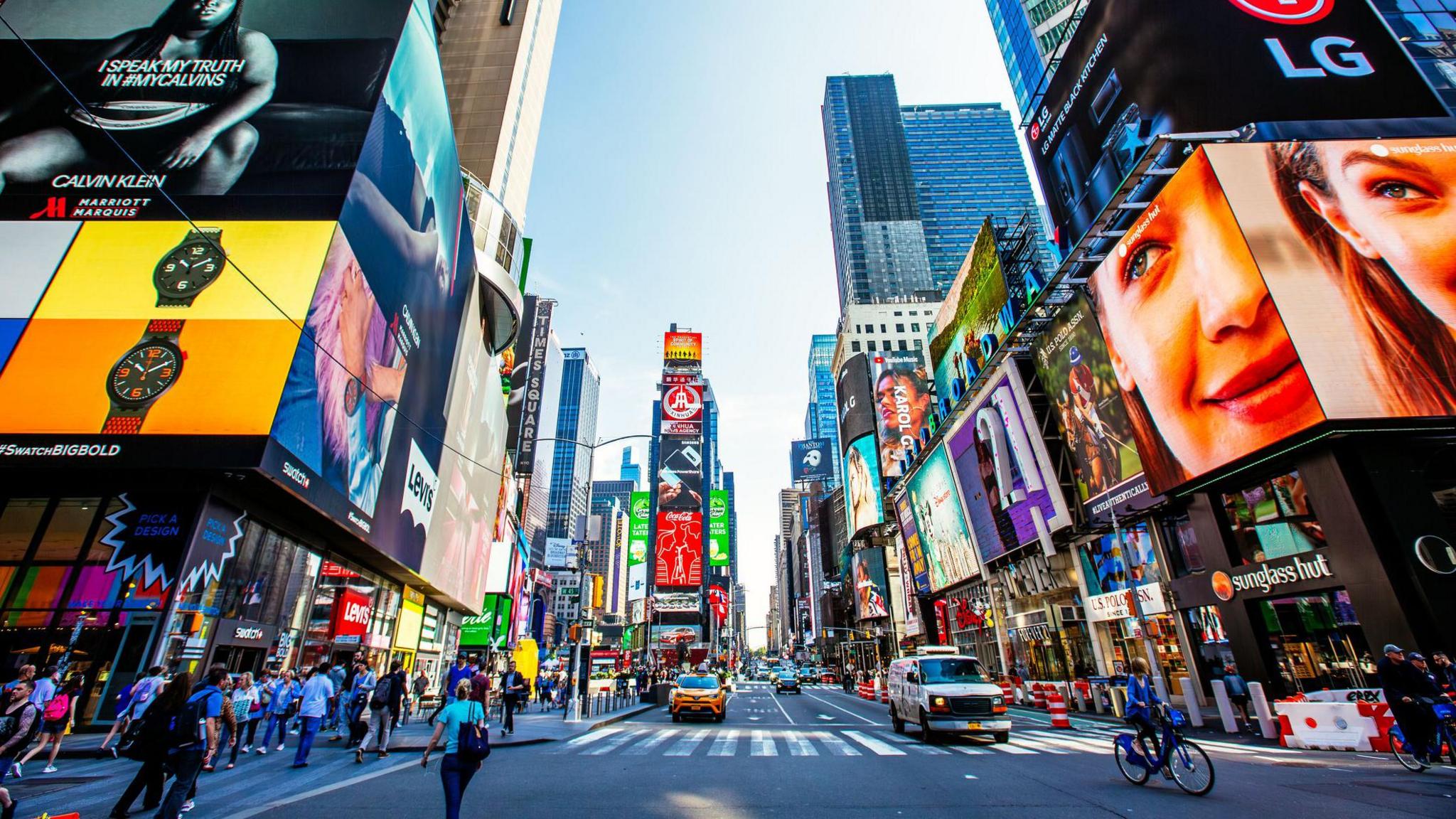 A view of Times Square in New York with a little traffic and people walking