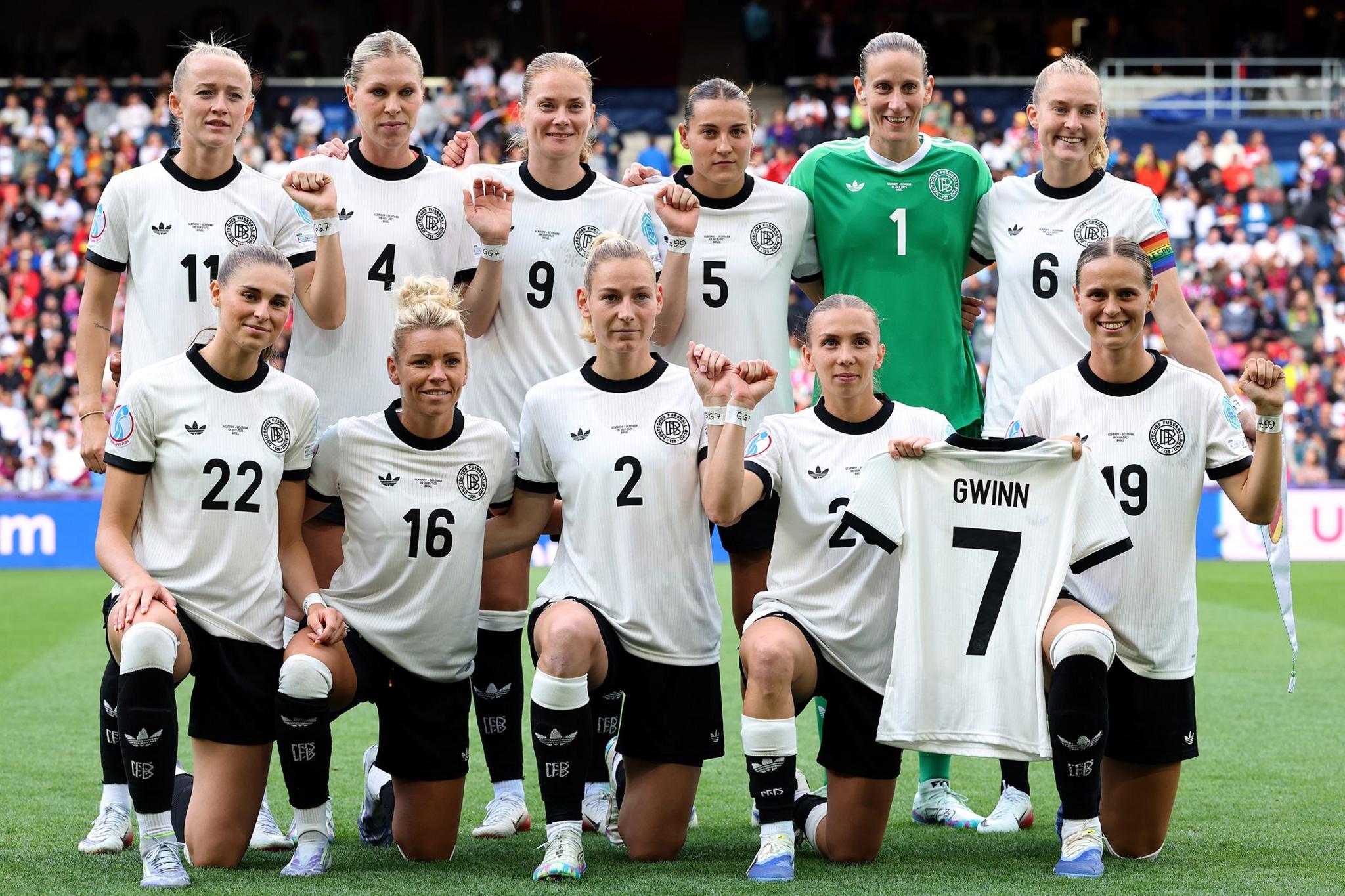 The German team pose holding a shirt of Germany captain Giulia Gwinn, who suffered a medial ligament injury in Germany's 2-0 victory against Poland, ruling her out of the remainder of the tournament. Photo by Alexander Hassenstein
