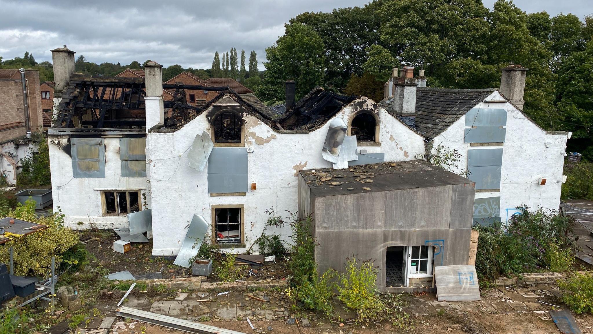 A large white building with a partially collapsed roof