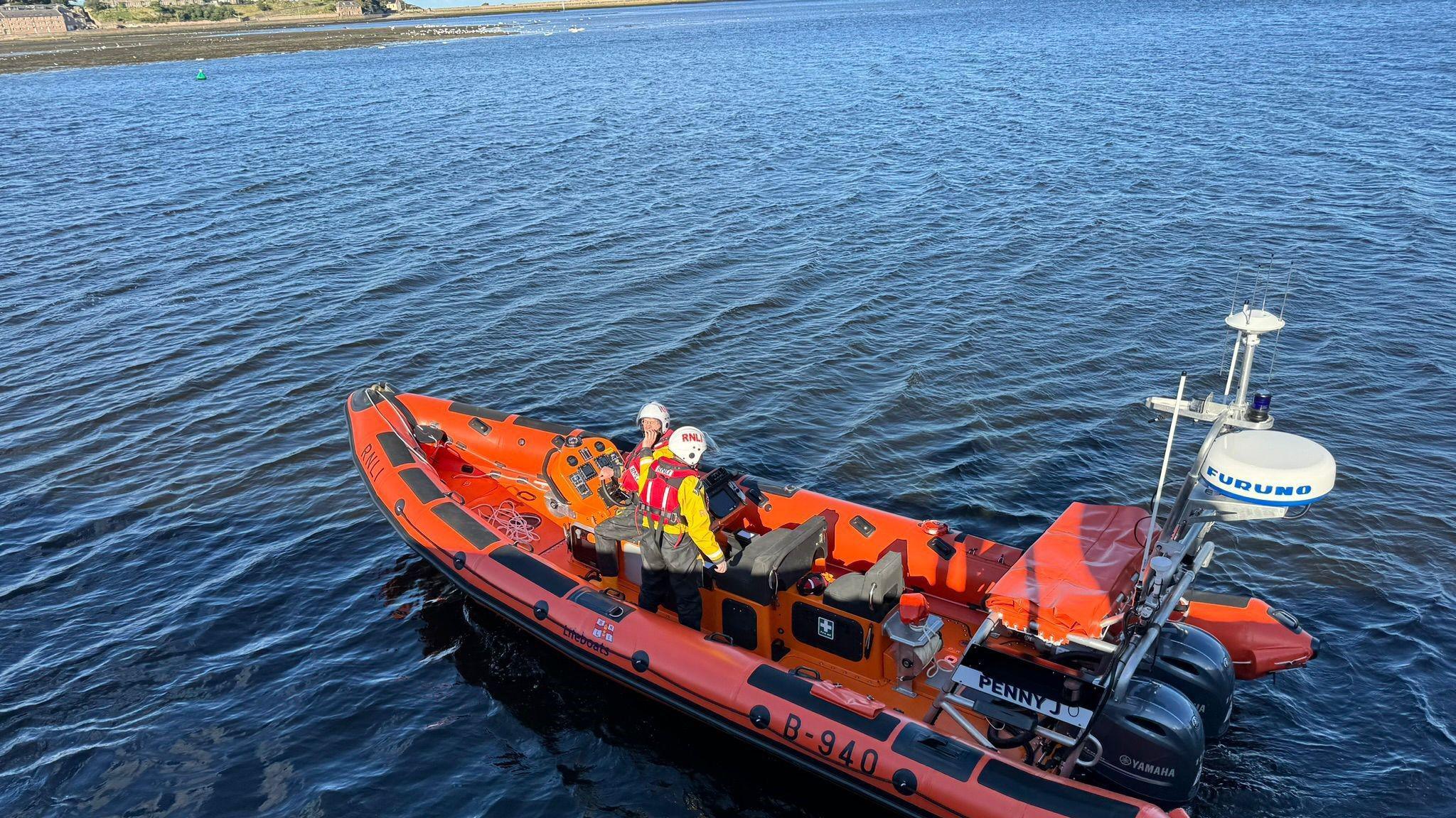 An Atlantic 85 lifeboat with two crew on board and the name, Penny J, visible towards the stern. 