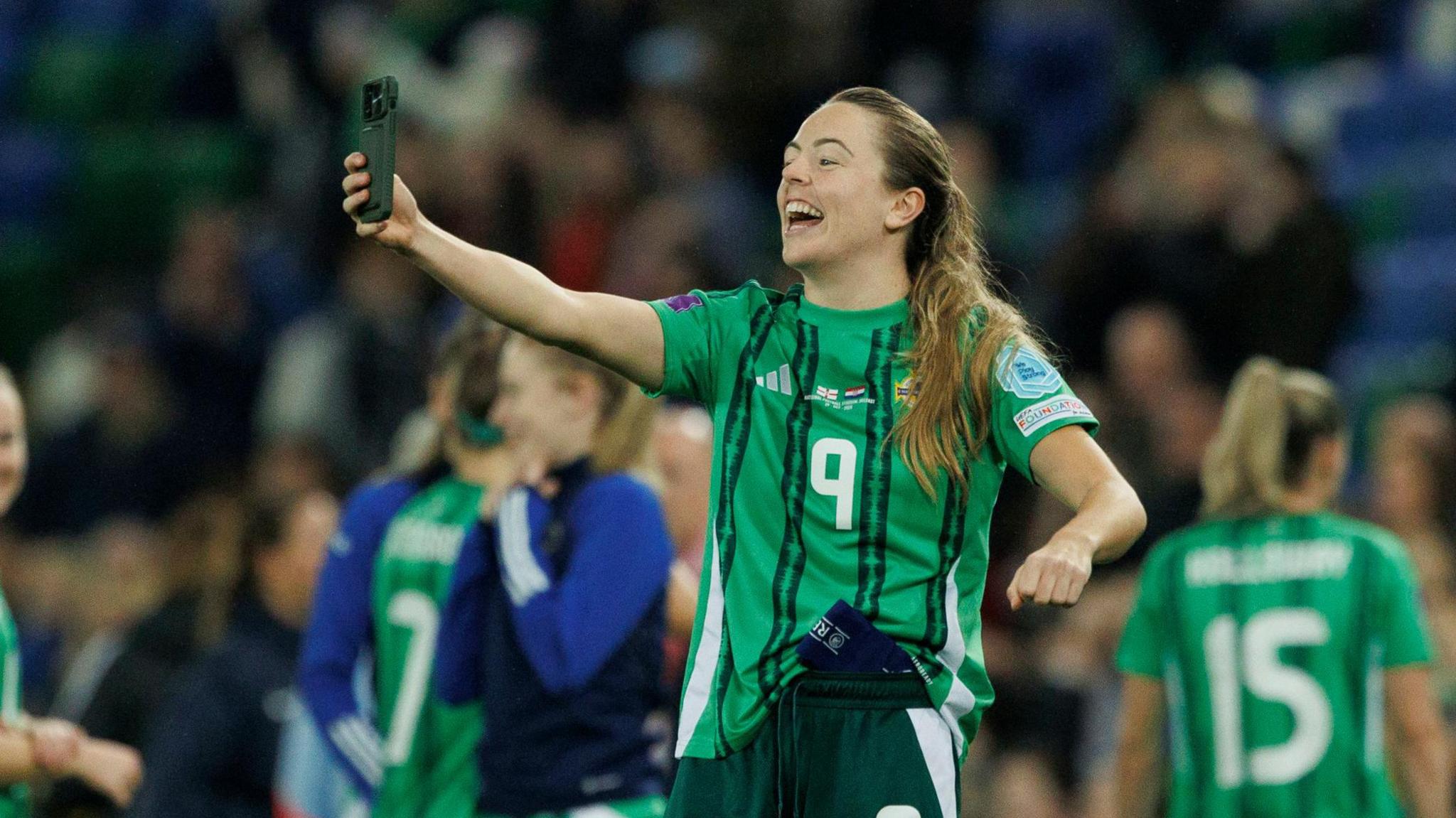 Image shows Simone Magill with a smartphone taking videos of the Northern Ireland fans after beating Croatia 