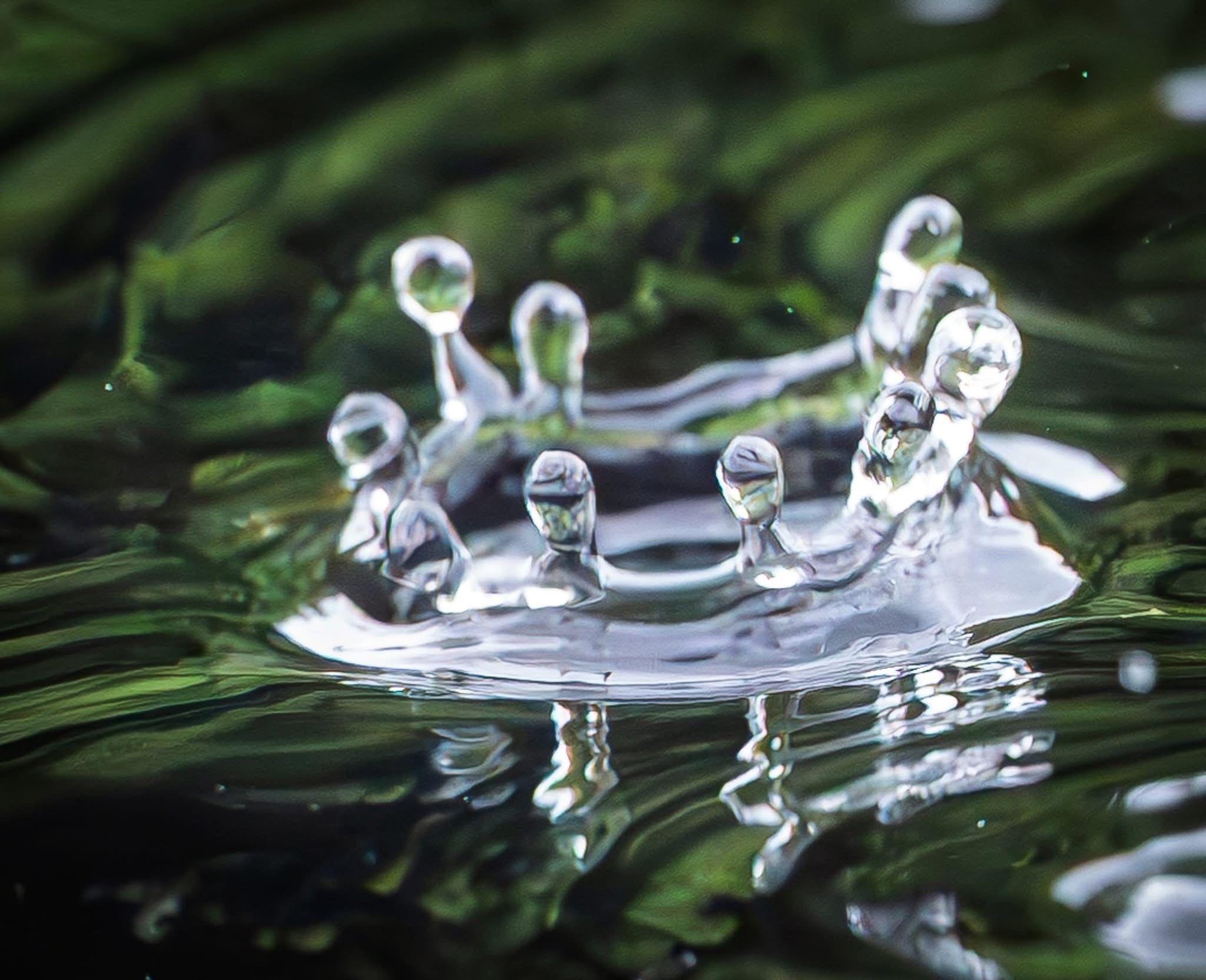 Extreme close up of the splashback of a water droplet hitting a body of water