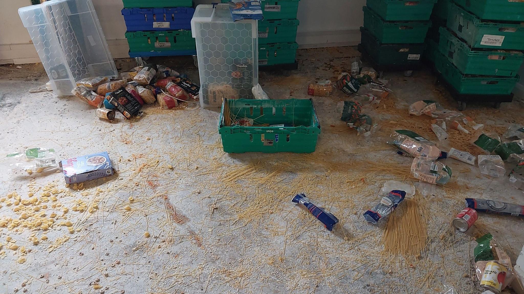The inside of Hart Foodbank after the break-in. Packets of pasta have been opened and there is pasta all over the floor. Crates and pallets are in disarray. A few cans are also rolling around.