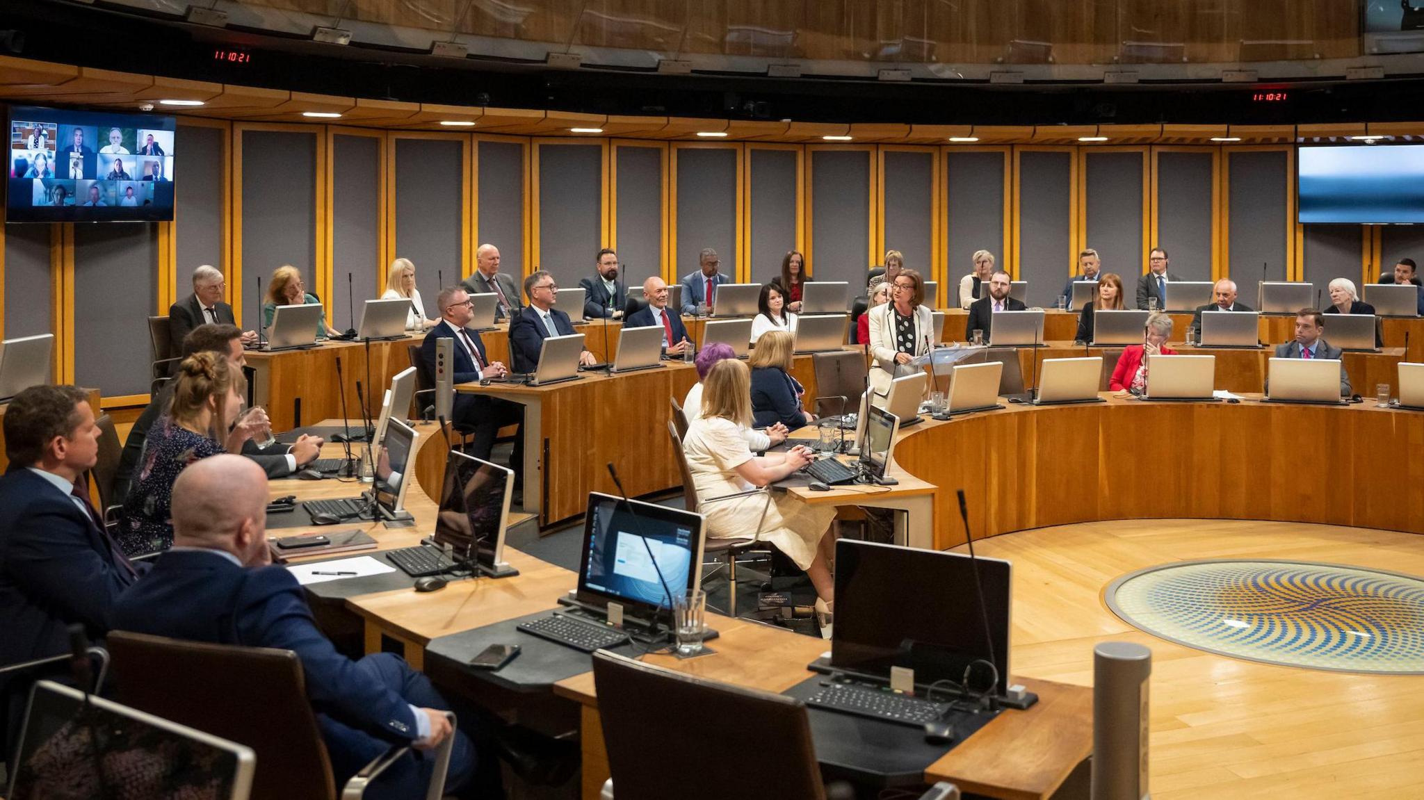 Senedd member listening to First Minister Eluned Morgan speak in the Welsh Parliament