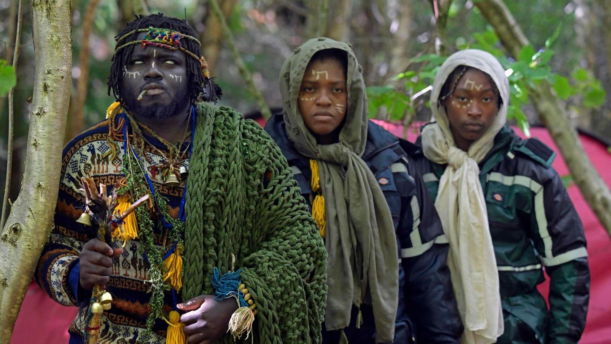 The three members of the self-proclaimed Kingdom of Kubala, clothed in knitwear, standing in woodland following their first official eviction.