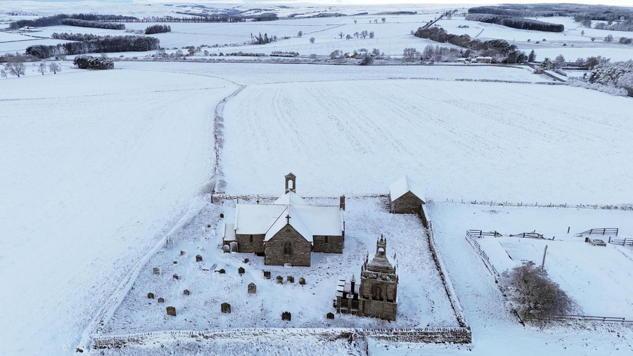 Aerial view of church in field of snow