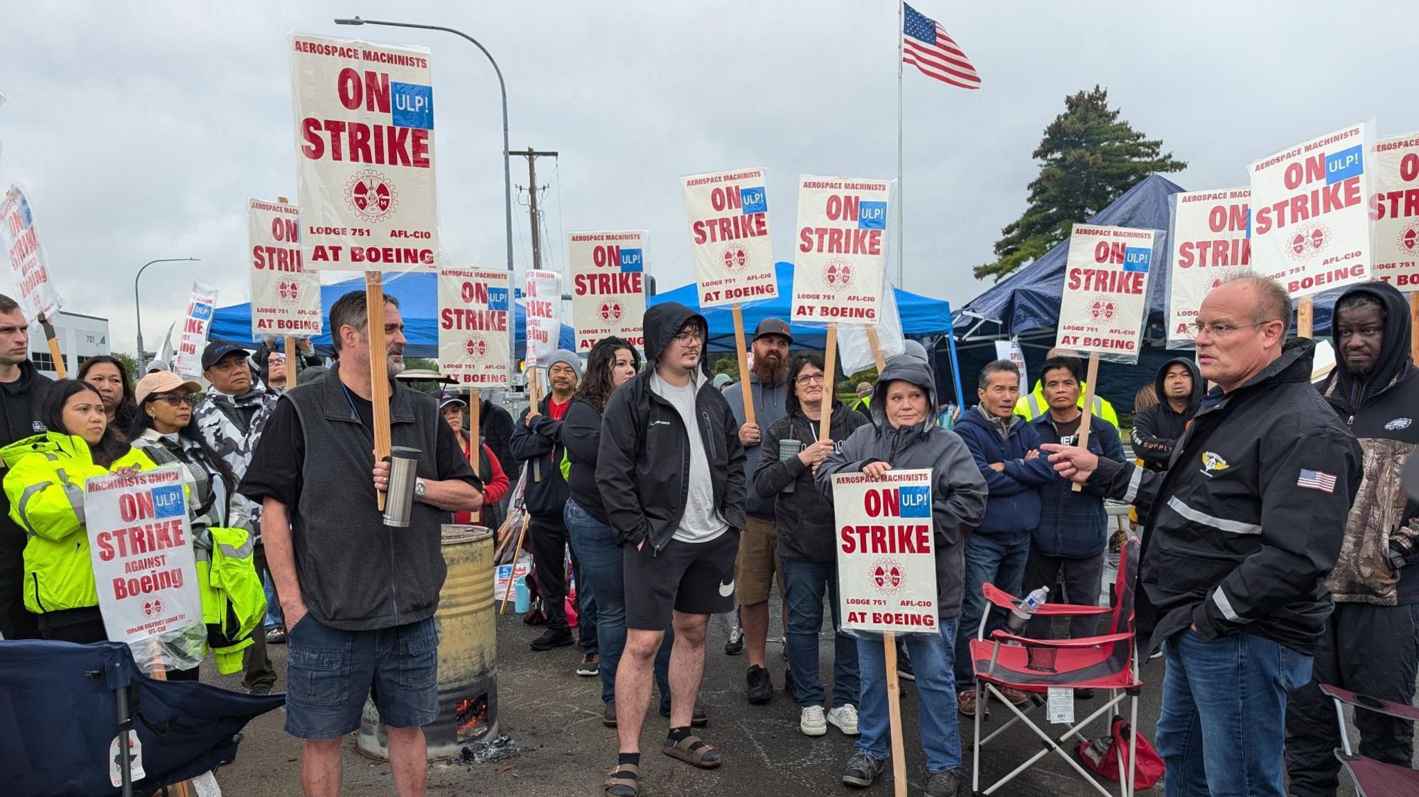 Union boss Brian Bryant, on the far right, talked to about 50 machinists on strike outside a factory in Auburn, Washington