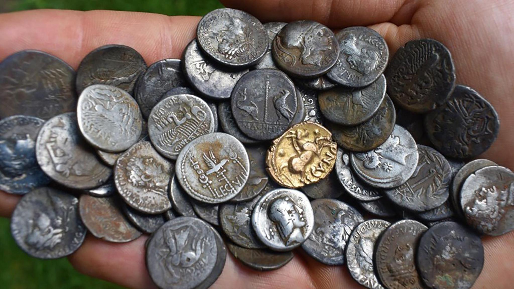 Some of the coins George Ridgway found during his hunt in Suffolk, in the palm of his hand.