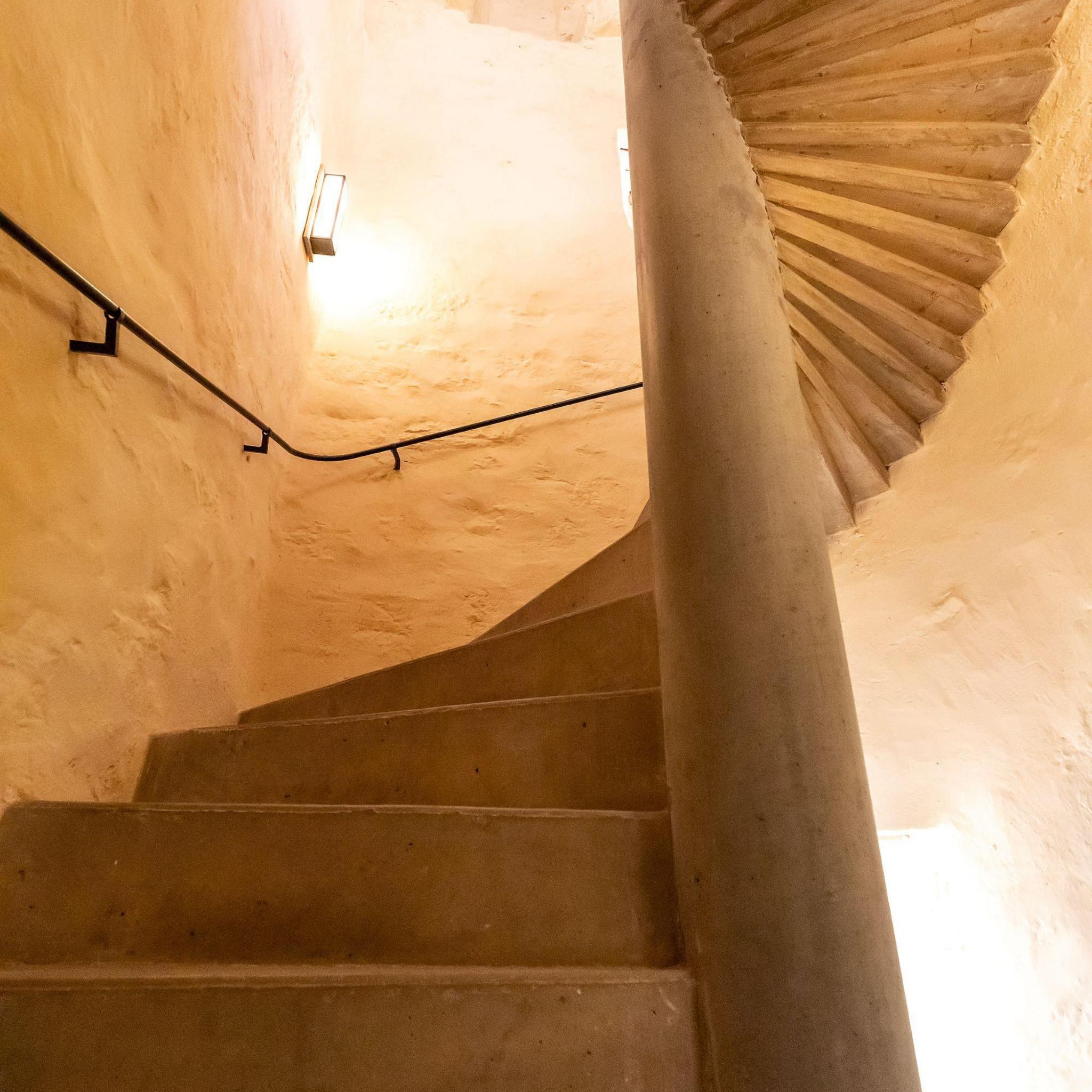 Fairburn Tower stairwell - with white painted stone walls and stone spiral steps.