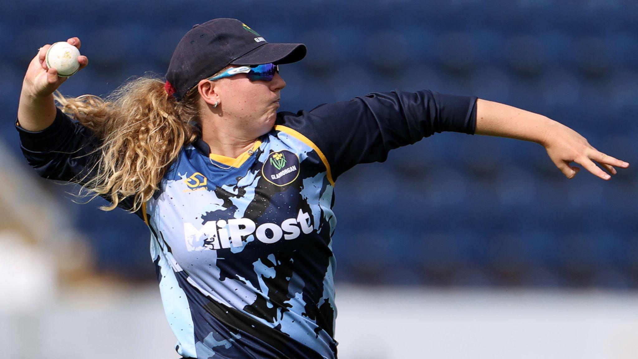 Gemma Porter in Glamorgan kit, cap and sunglasses throwing a white ball with other arm outstretched