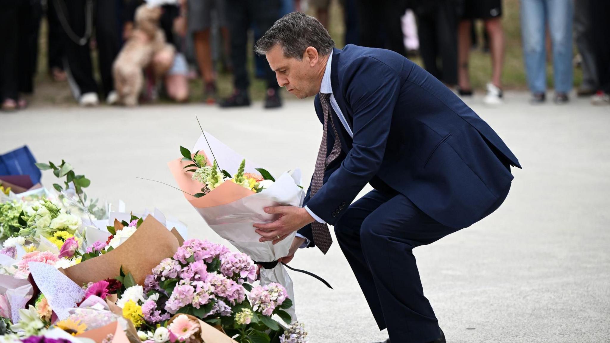 Ministri i Shëndetësisë i NSW-së, Ryan Park, vendos lule në një memorial në Bondi Beach