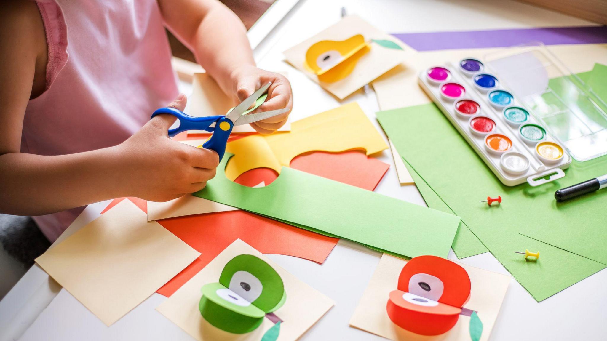 Stock photo of a young girl doing paper crafts