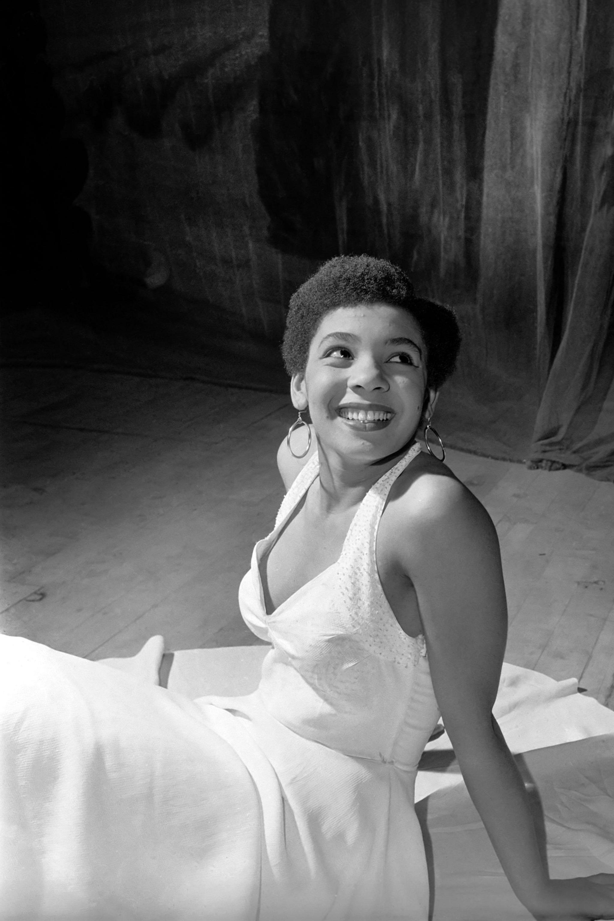 A black and white photo of a young Shirley Bassey on stage