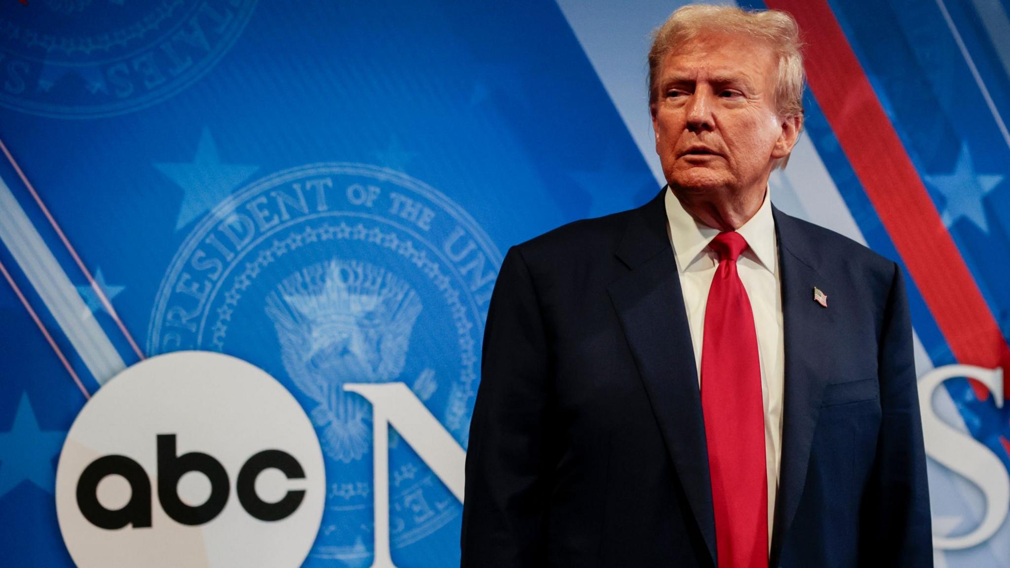 Donald Trump stands beside the ABC News logo before the final presidential debate in September