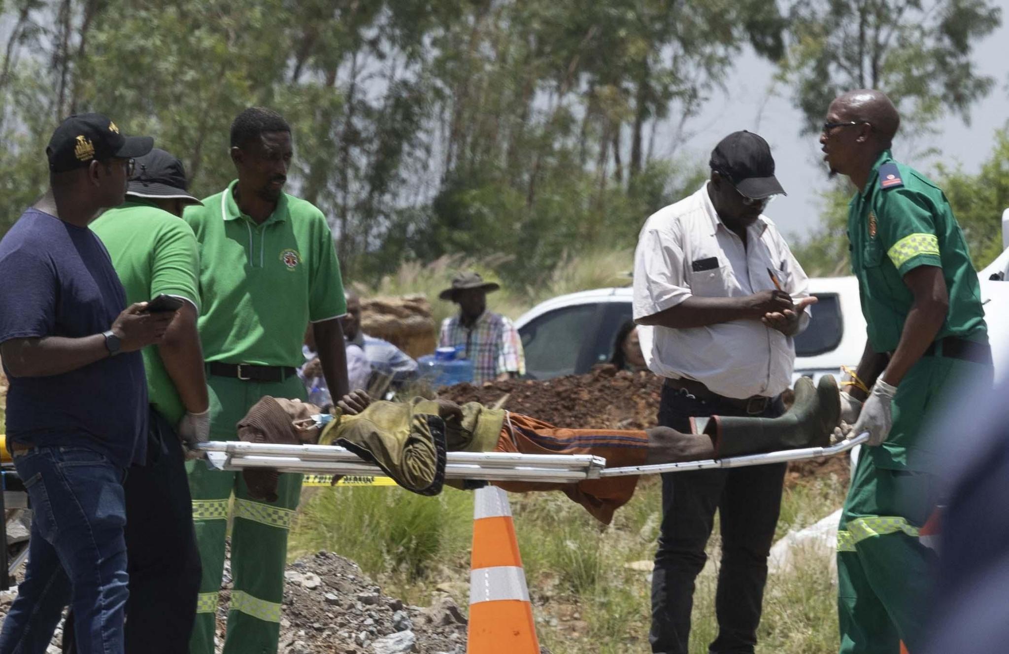 A man in tattered clothing is stretchered away.