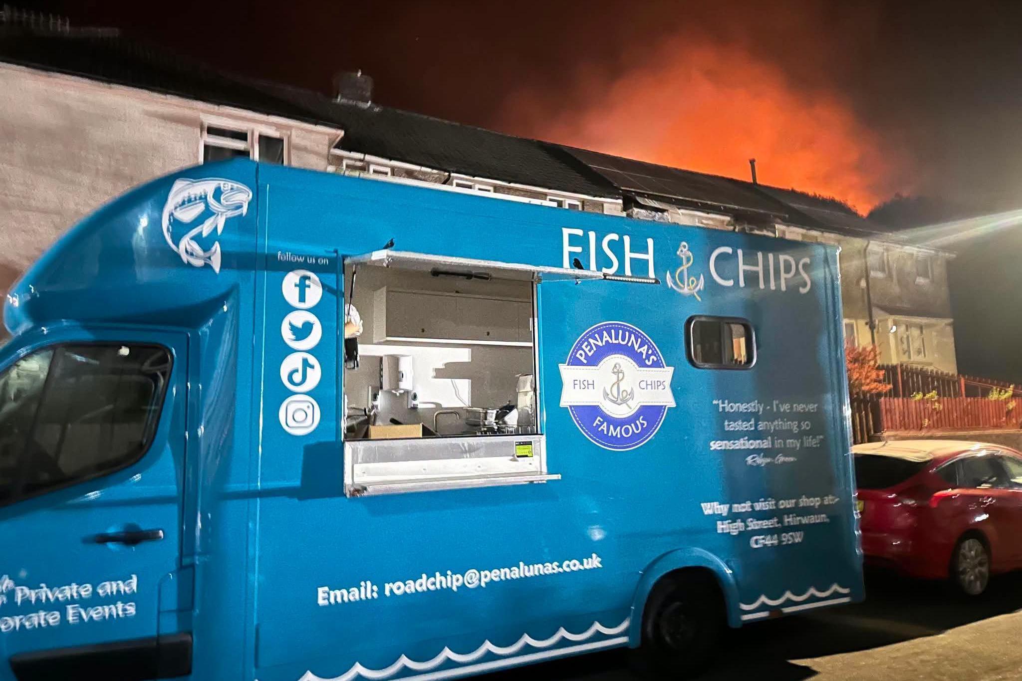 Penaluna fish and chip van from Hirwaun parked on a street as firefighters tackle a wildfire blaze on the nearby Rhigos mountain