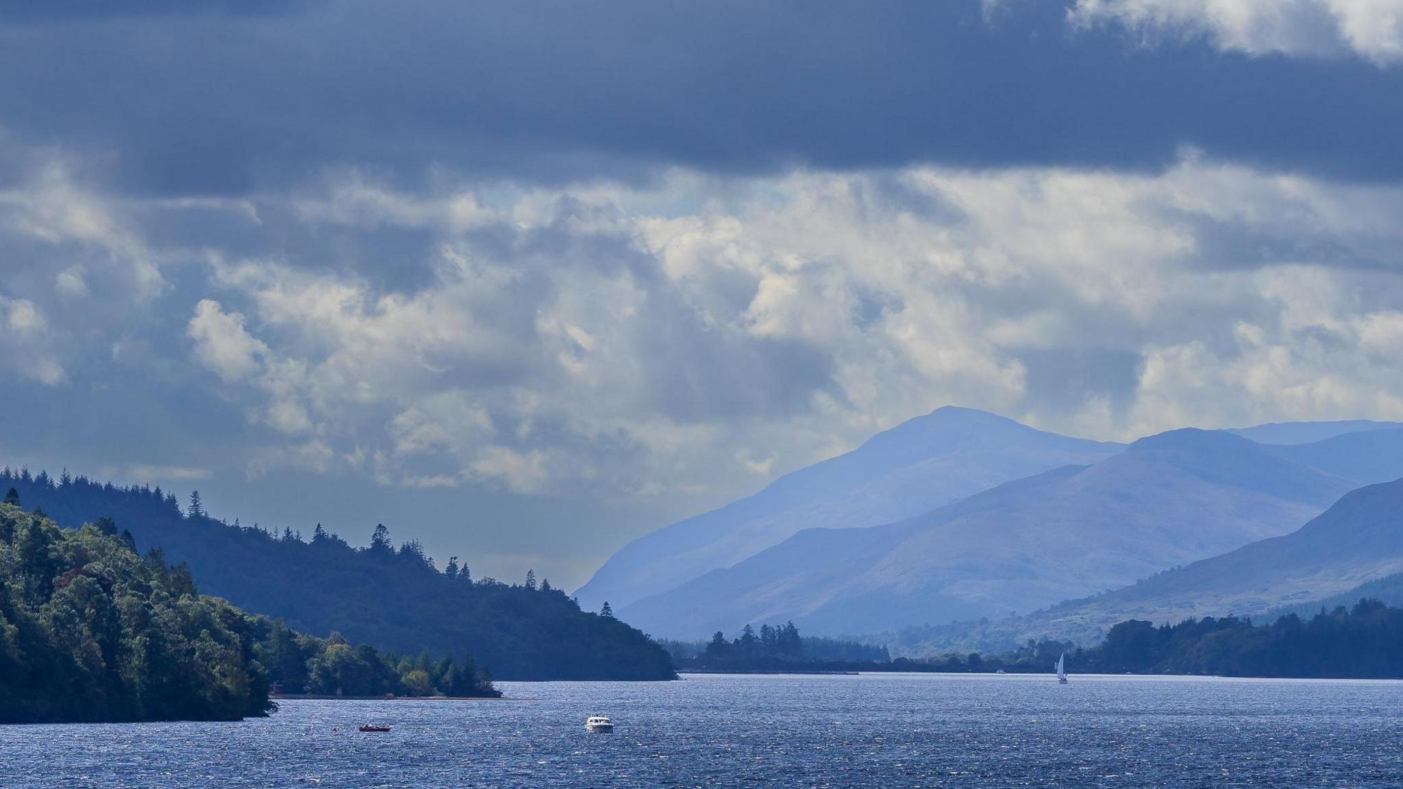 A view down Loch Lochy, with a blue haze on mountains in the distance.