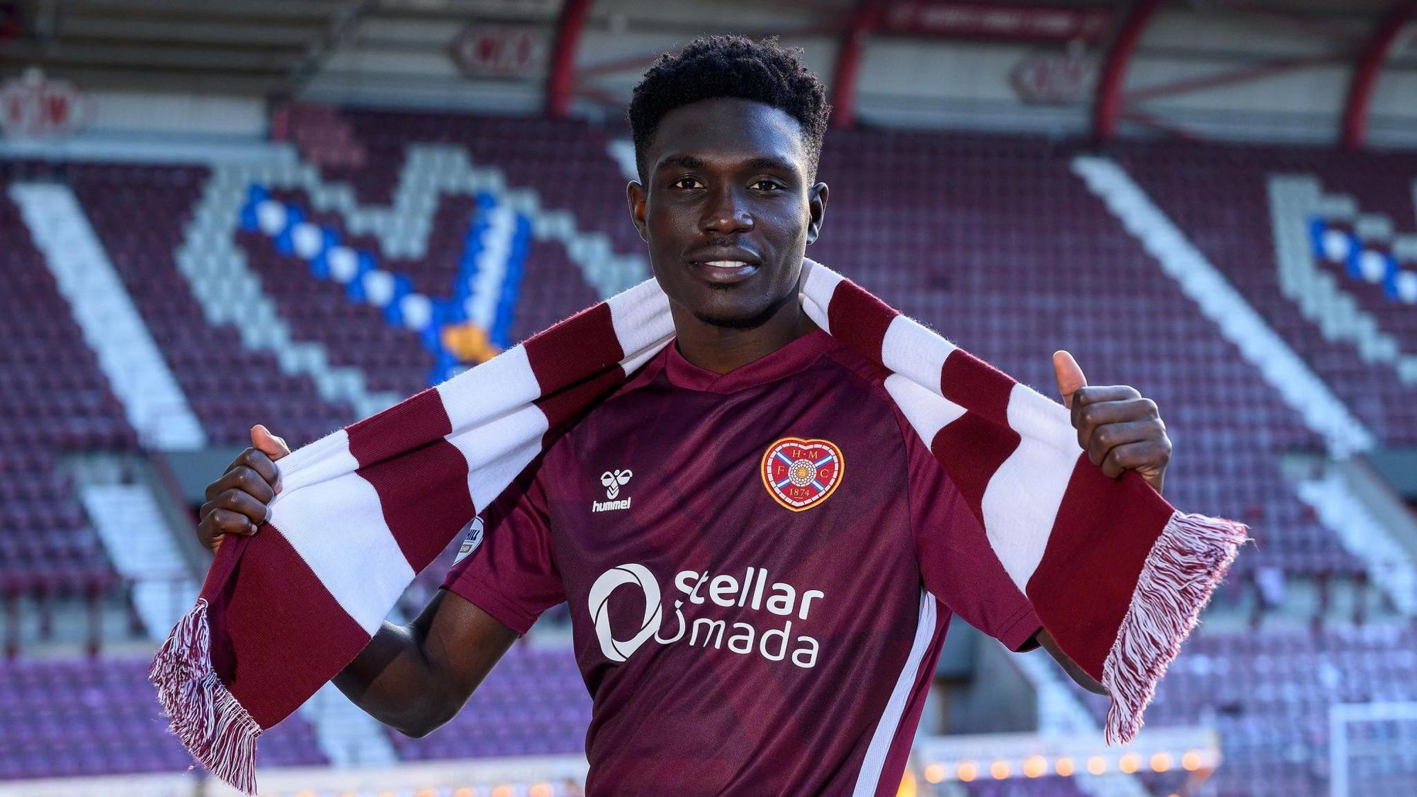 Rogers Mato poses for photos at Tynecastle after signing for Hearts