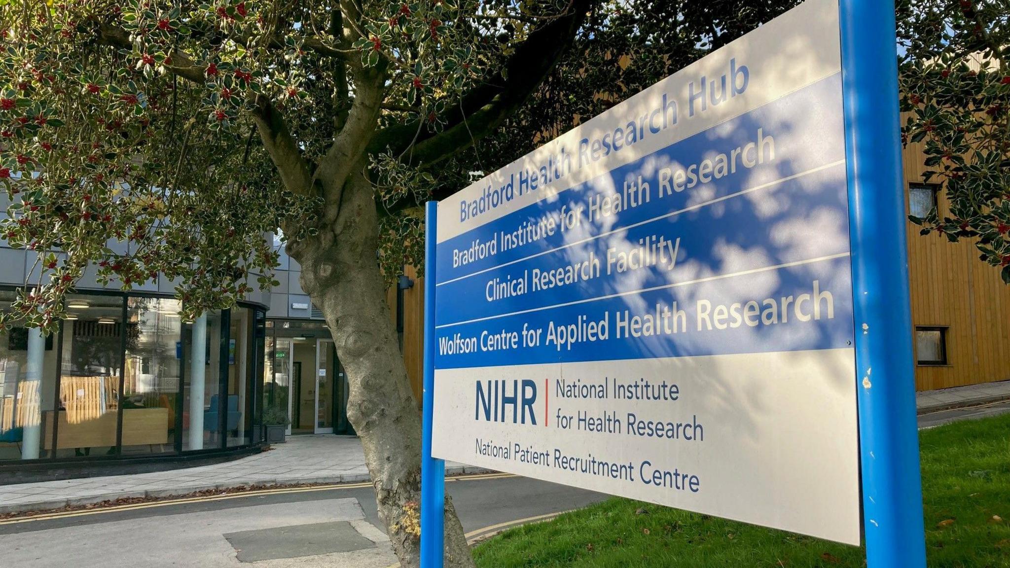 A blue and white sign outside a medical research building