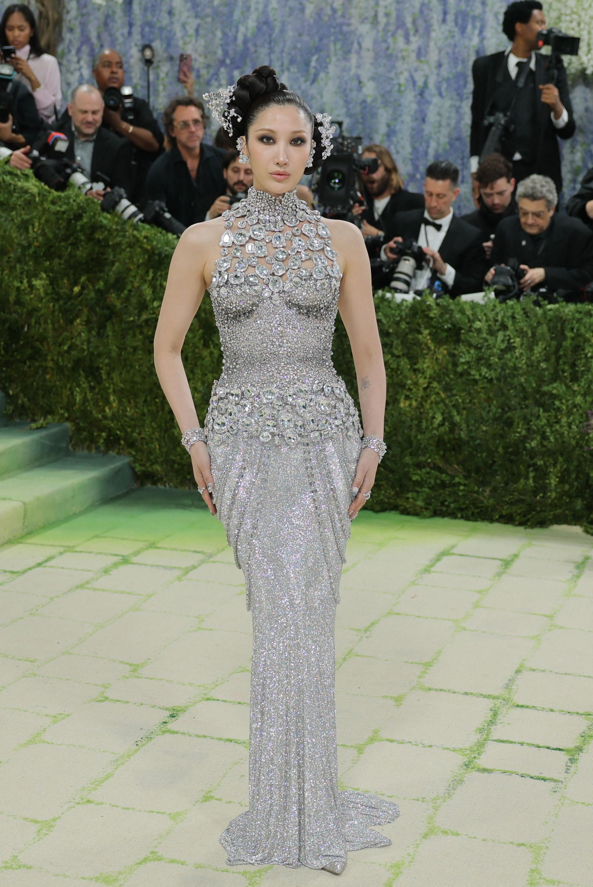 Ejae poses during the Met Gala wearing a diamond covered halter-neck dress.