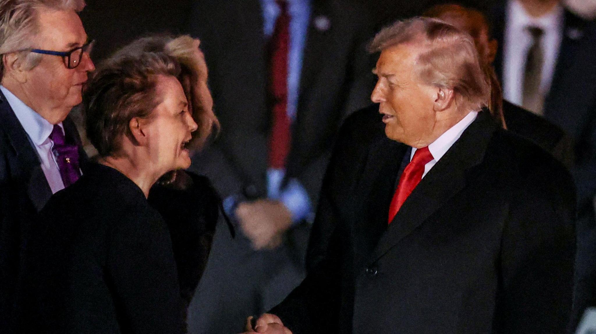 Yvette Cooper is to the left hand side of the shot and President Trump to the right.
He is wearing a red tie.
They are shaking hands as she welcomes him to the UK on his state visit. 