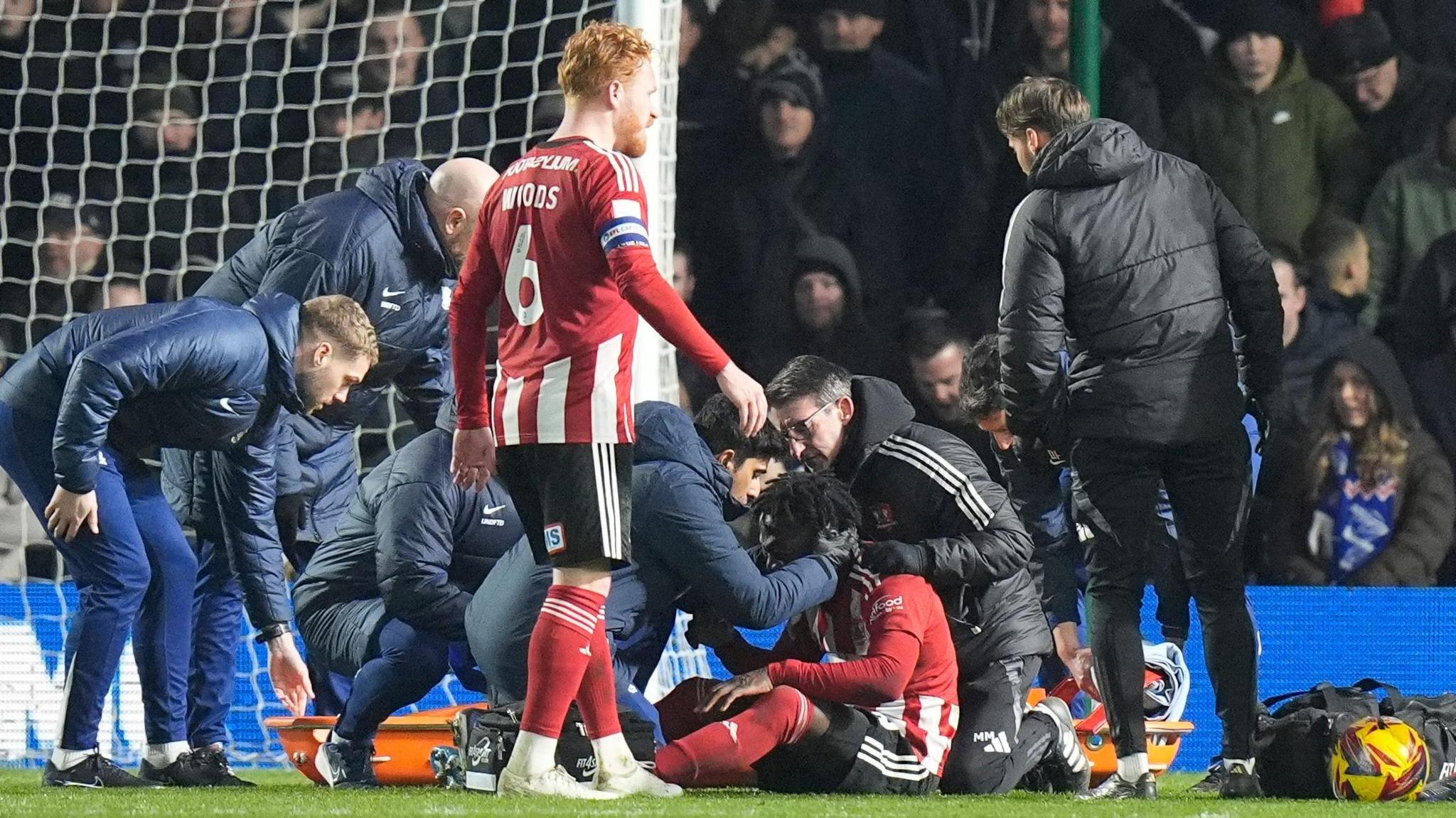 Exeter defender Vincent Harper receives treatment after a clash of heads in the game against Birmingham City