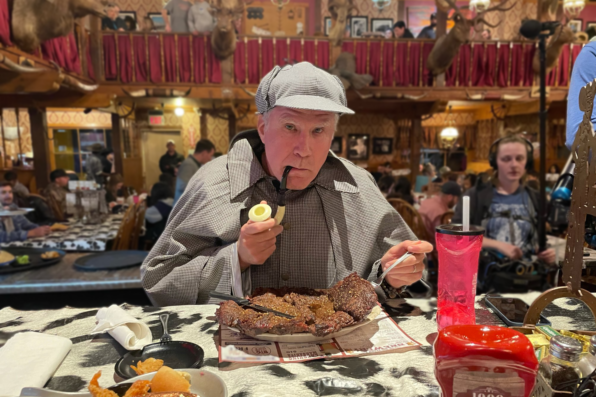 Will Ferrell wearing a Sherlock Holmes costume - a dogtooth cape, matching hat and a pipe - in front of a huge steak on a plate in a restaurant