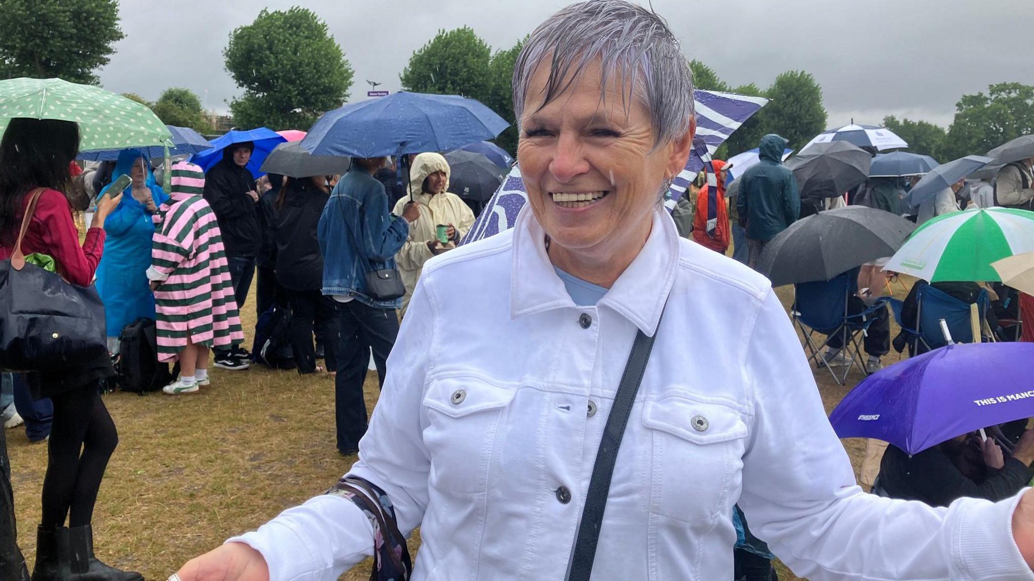 A woman in a white shirt. She looks drenched.