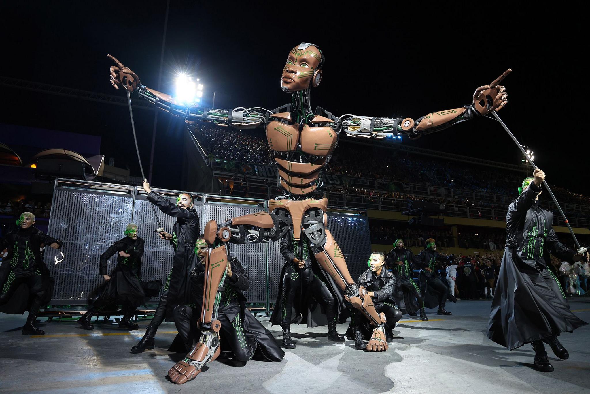 A robot puppet and performers dressed in black from the Mocidade Independente de Padre Miguel school