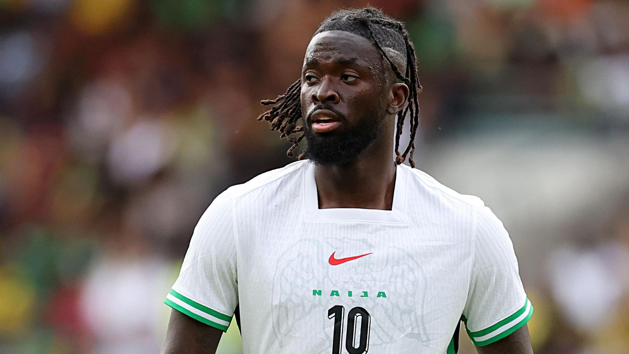 Tolu Arokodare, wearing a white Nigeria shirt with green trim along with the word Naija and a number 10 on the chest