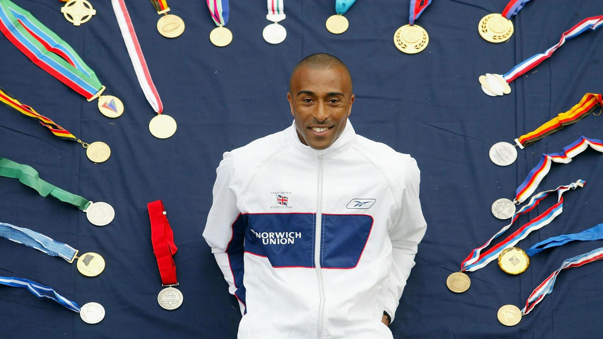 Colin Jackson poses alongside his impressive medal collection, which contained every major title outside of the Olympics