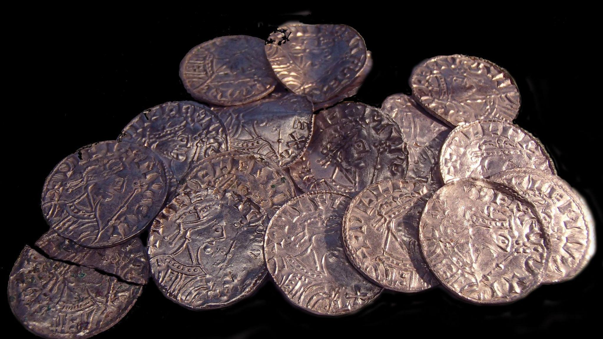A pile of around 17 copper-coloured coins featuring a bust of a man on. 