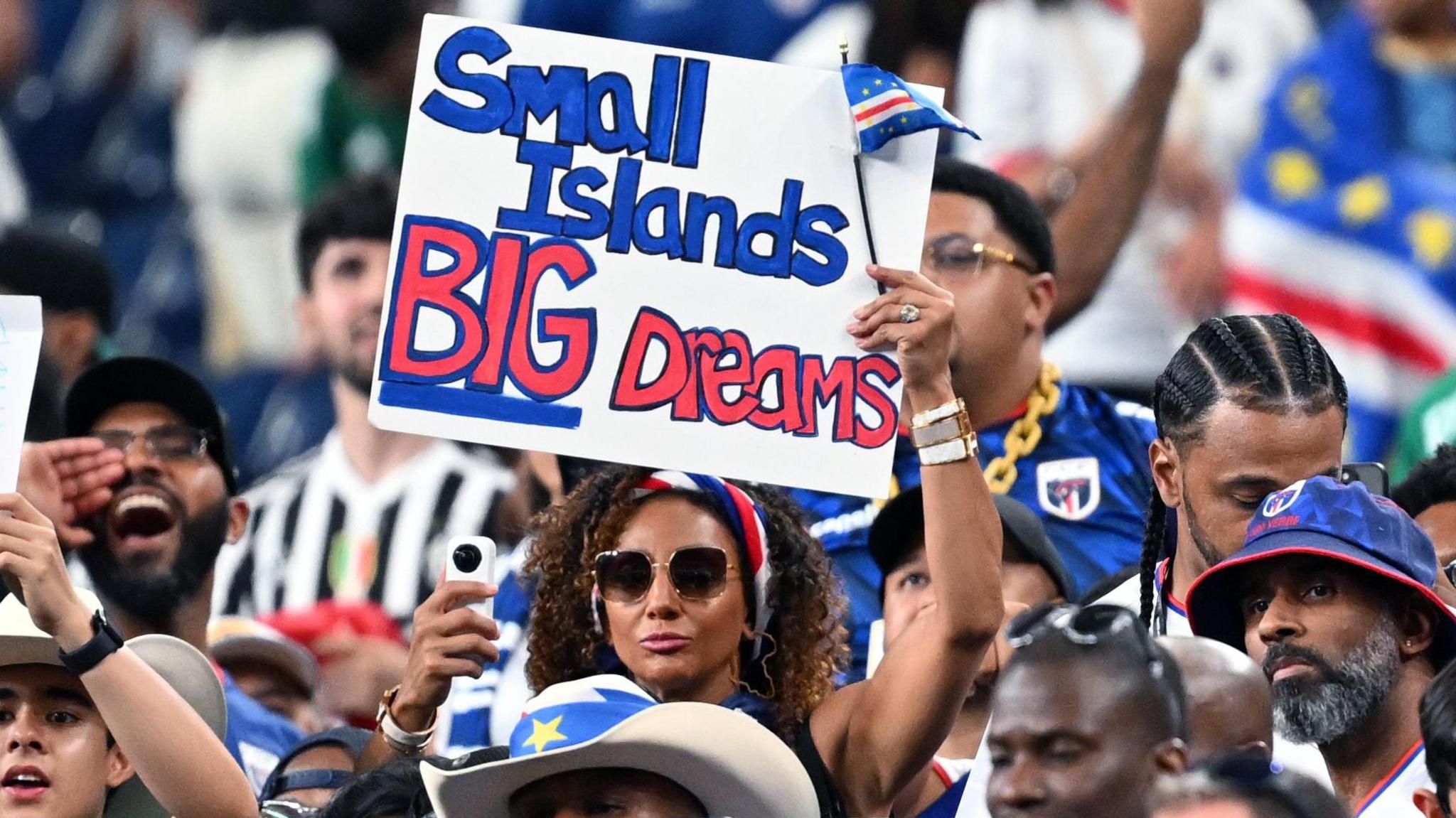 fan during match holding sign saying 'small islands, big dreams'