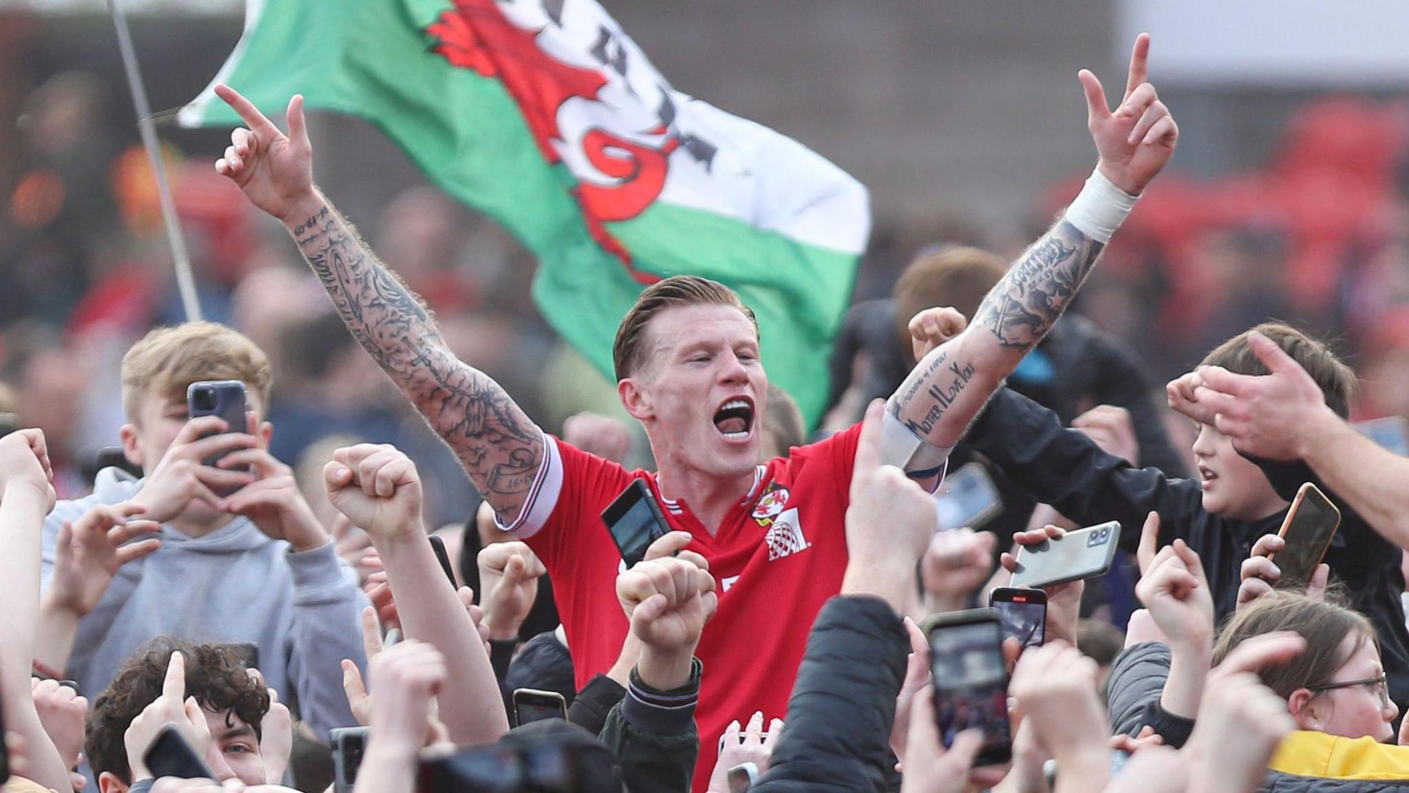 James McClean of Wrexham celebrates during the pitch invasion at full-time against Forest Green