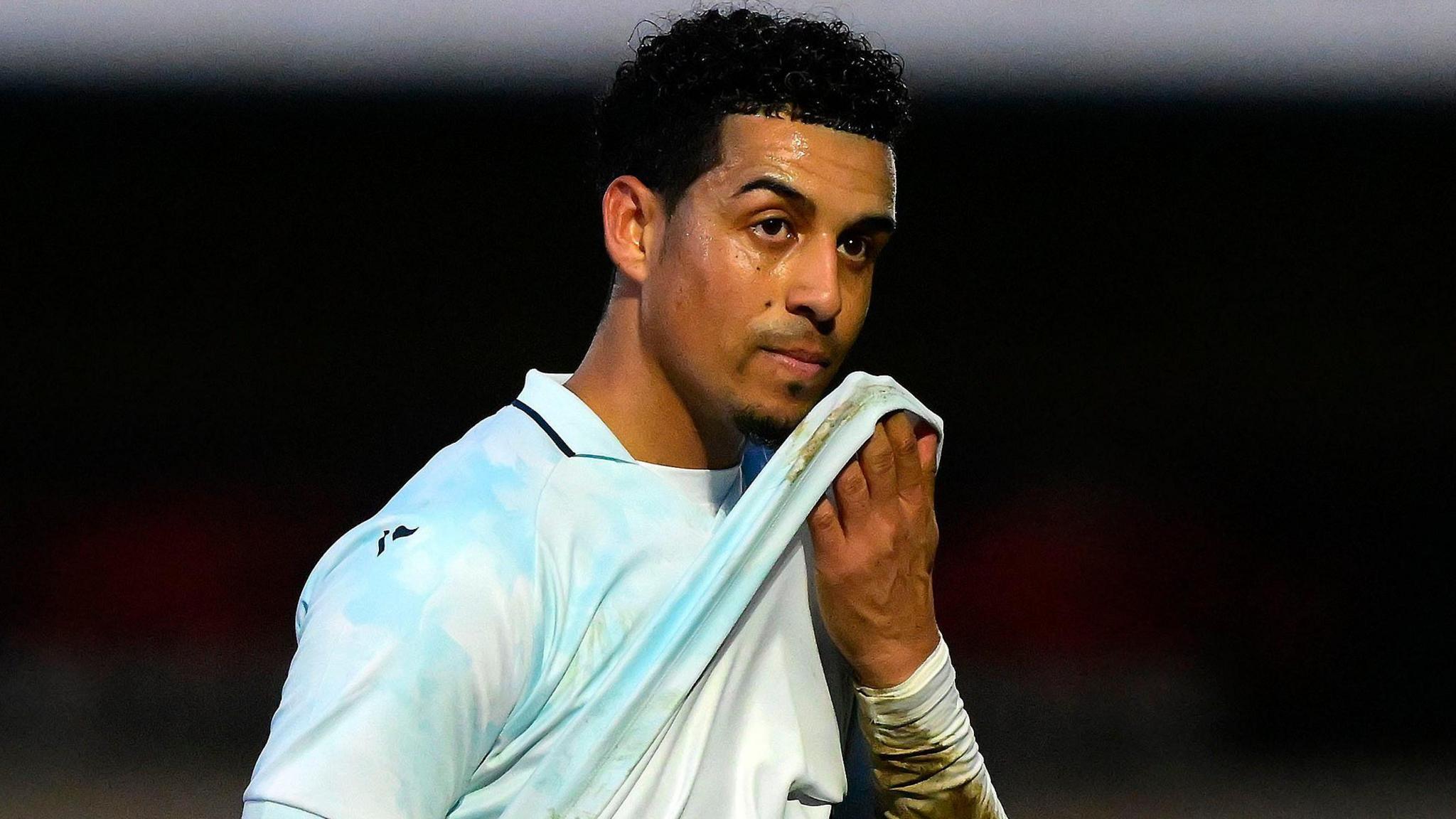 Louis Dennis walks off the pitch having been sent off