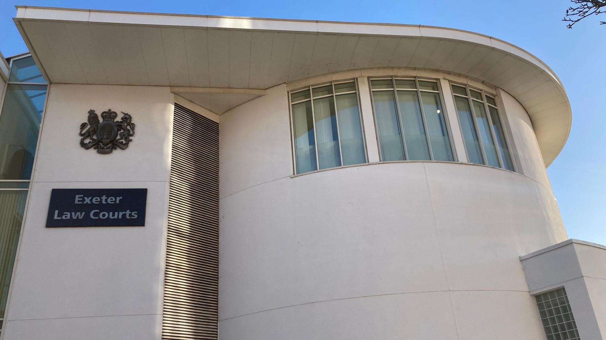 External photograph of Exeter Crown Court, a large, modern, white building. 