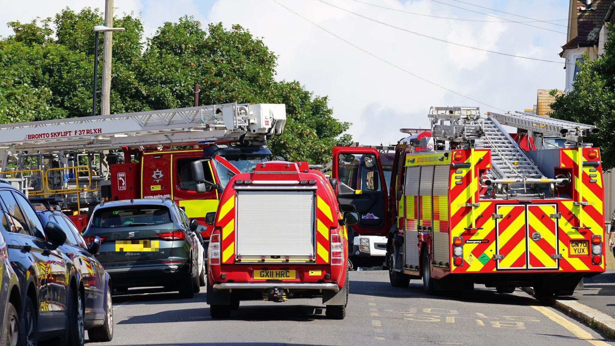 Fire engines on the scene, there are three visible and they are blocking the road