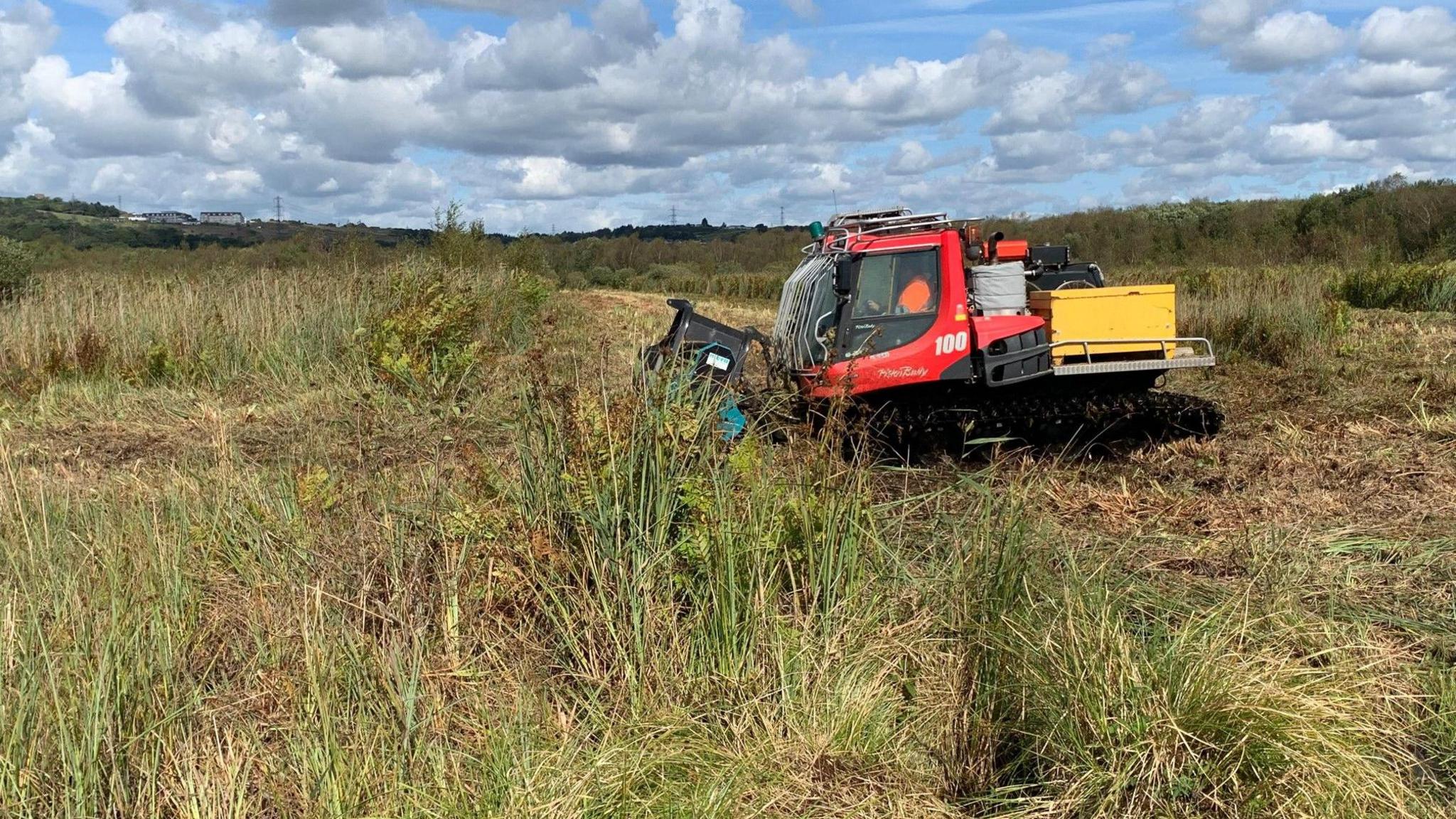 Restoration work at Crymlyn Bog being carried out, with machinery visibile in the foreground 