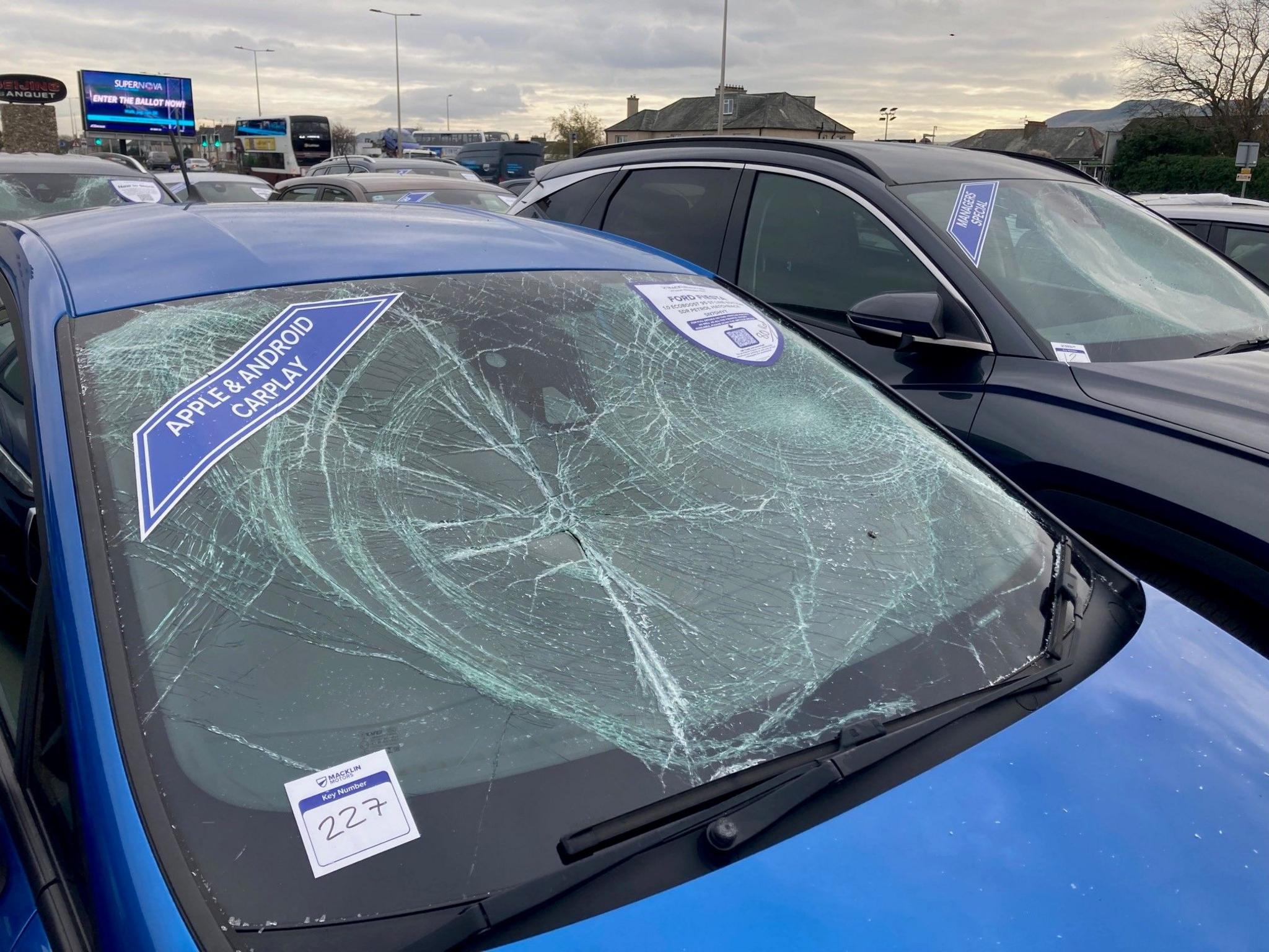 A blue car parked at the Macklin Motors Hyundai car dealership - the windscreen remains in place but is completely smashed