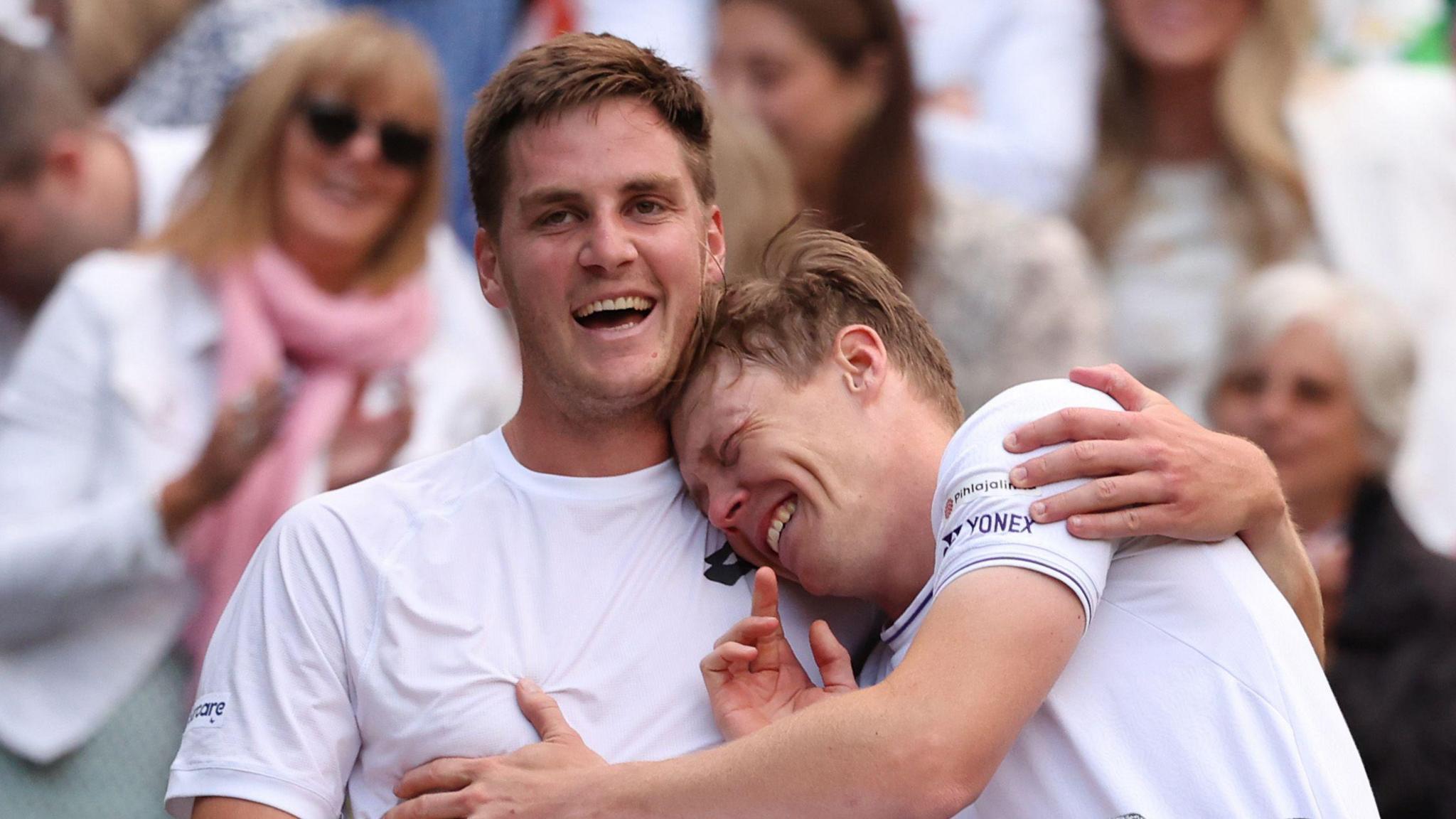 Henry Patten and Harri Heliovaara laugh and hug after winning the Wimbledon men's doubles title