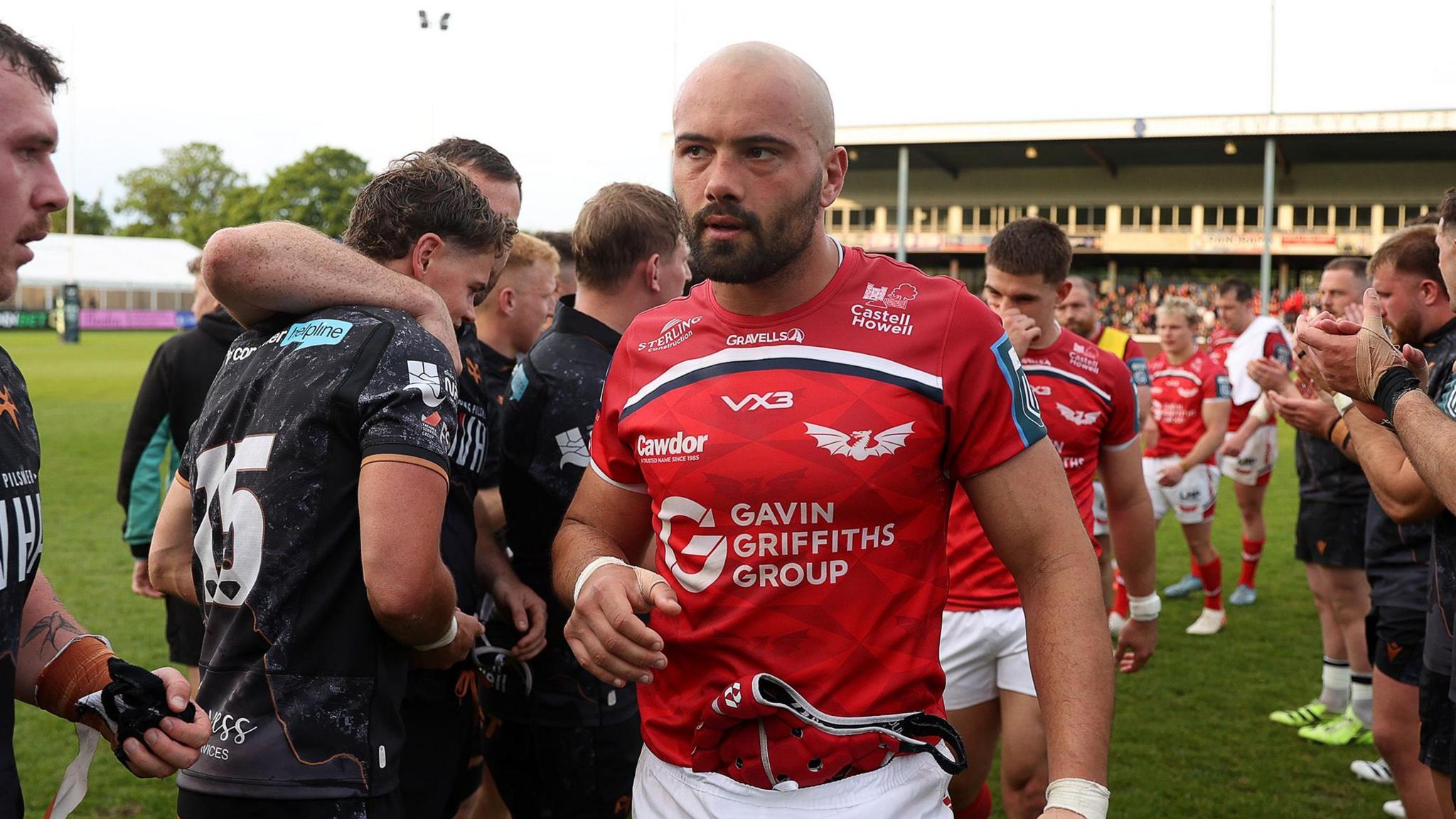 Josh Macleod leads Scarlets off the field at Ospreys