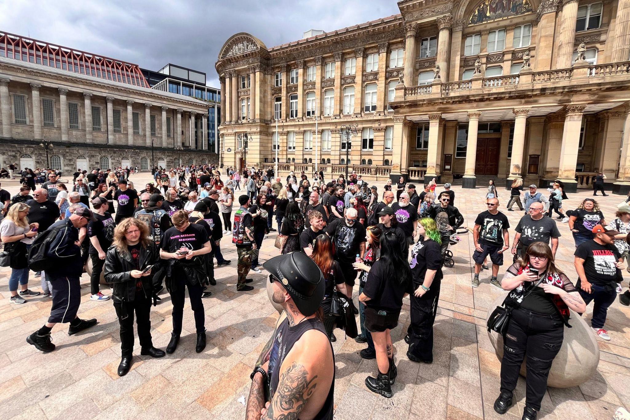 Black Sabbath fans, many dressed in black, congregate in Birmingham's Victoria Square